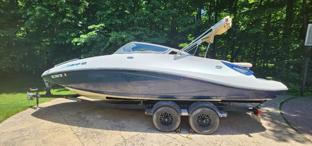 A 2007 Sea-Doo Sport Boat 230 Challenger SE on a trailer, surrounded by trees.