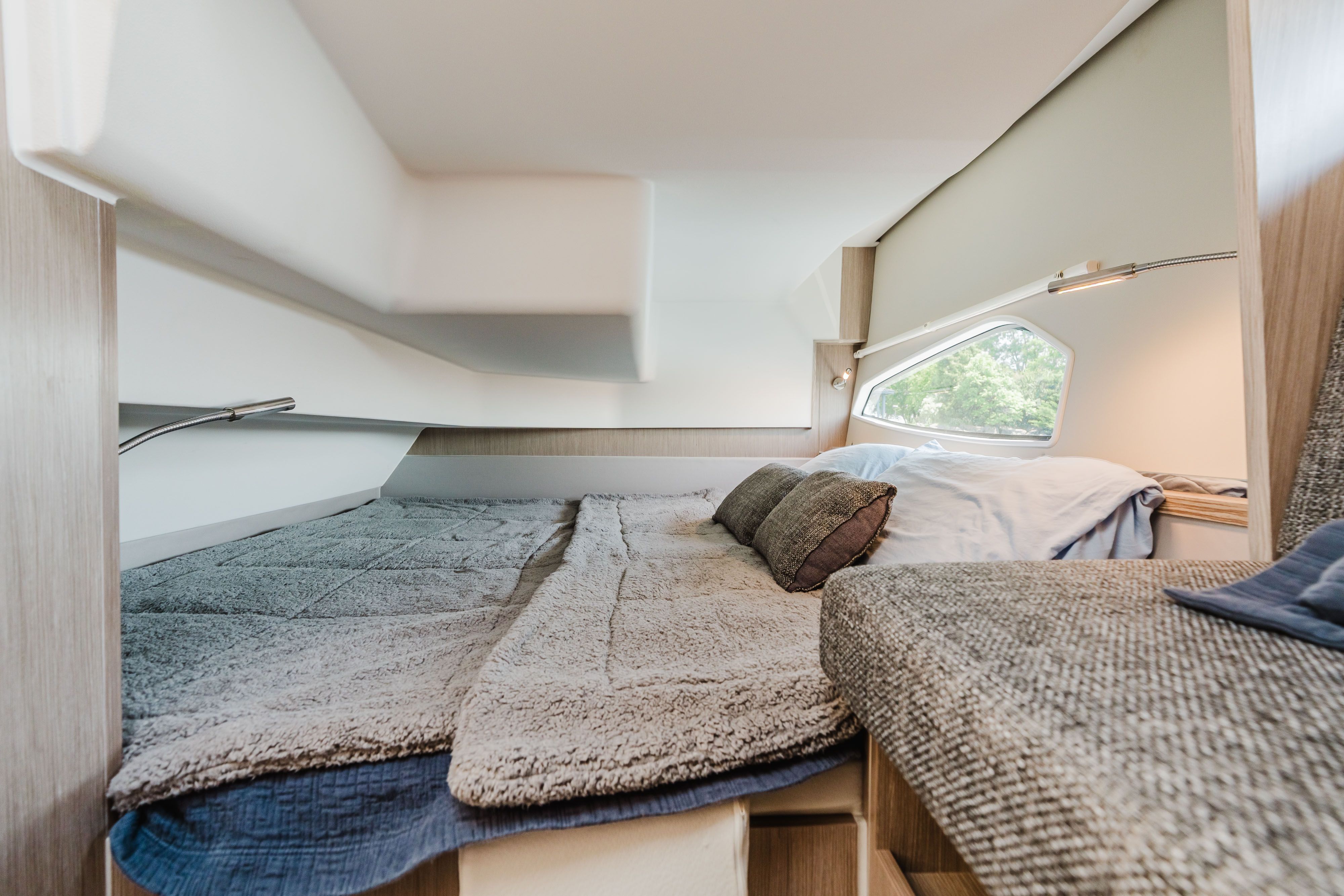 Interior of the 2023 Sealine C335V with a cozy bed and windows.