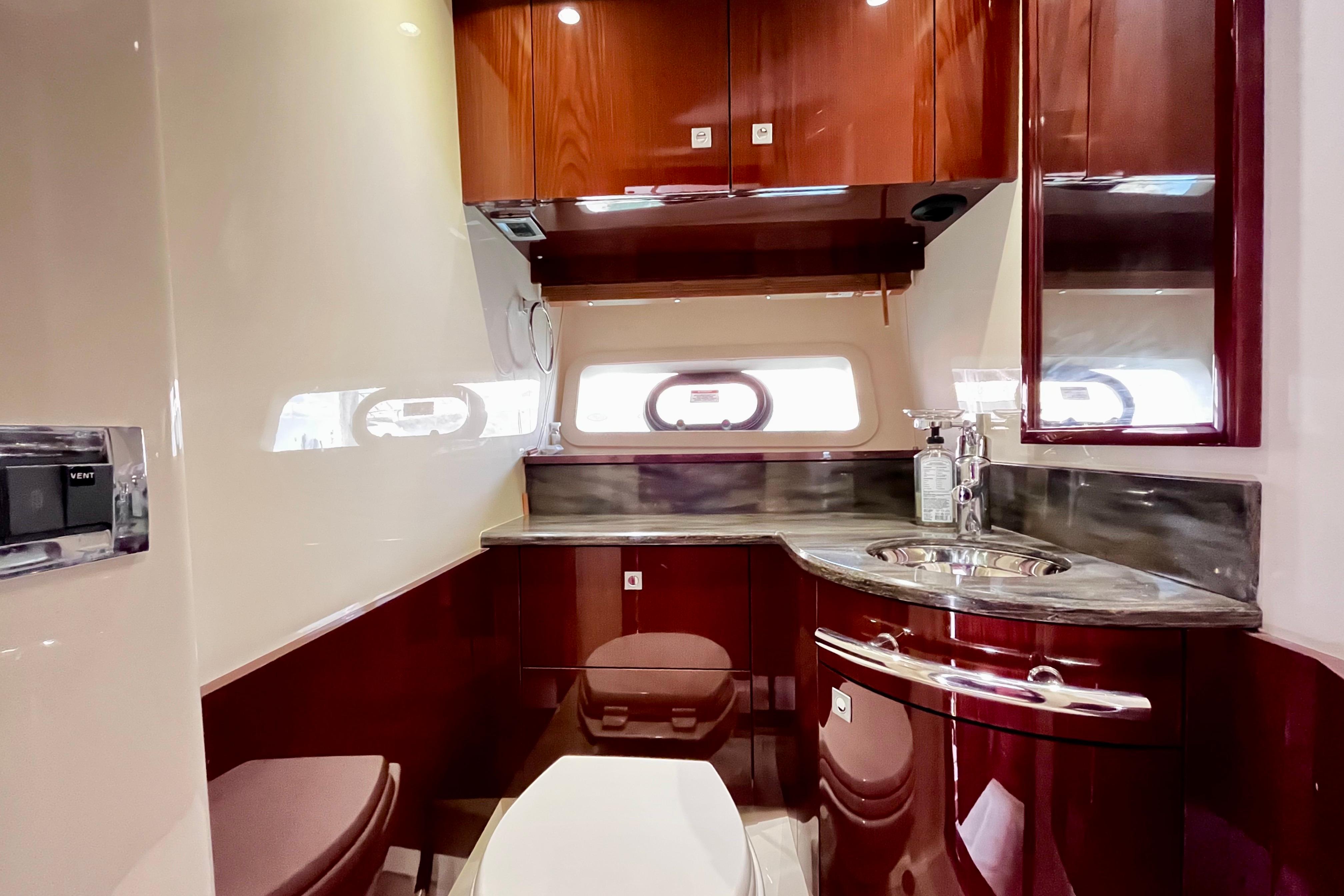 Luxurious bathroom interior of 2015 Sea Ray 470 Sundancer yacht with elegant wood finish.