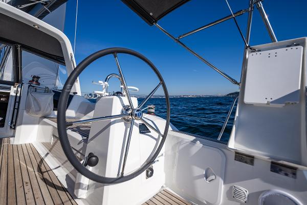 Helm of Beneteau Oceanis 38.1 yacht on open sea.