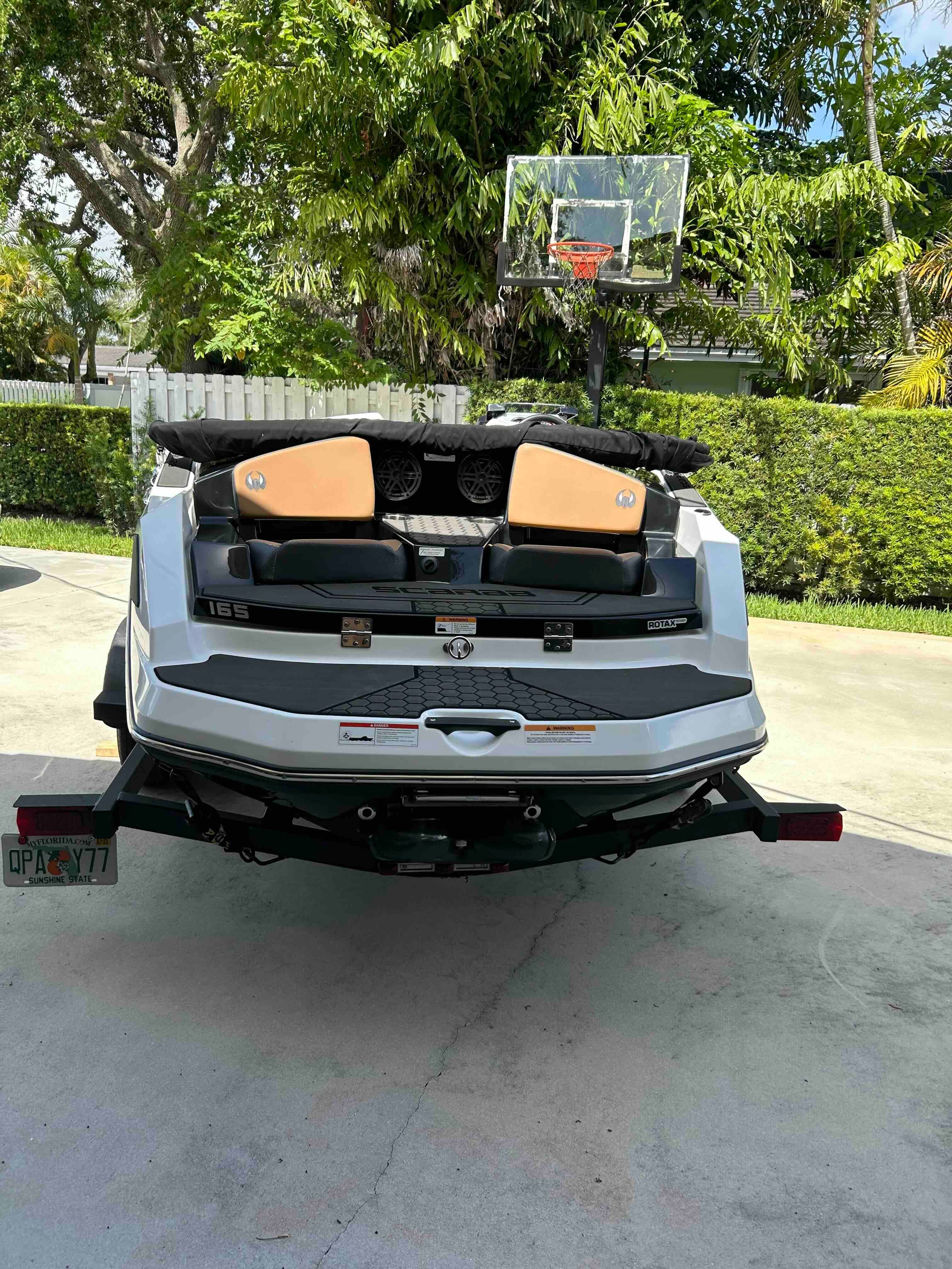 A 2022 Scarab 165 ID boat on a trailer in a driveway.
