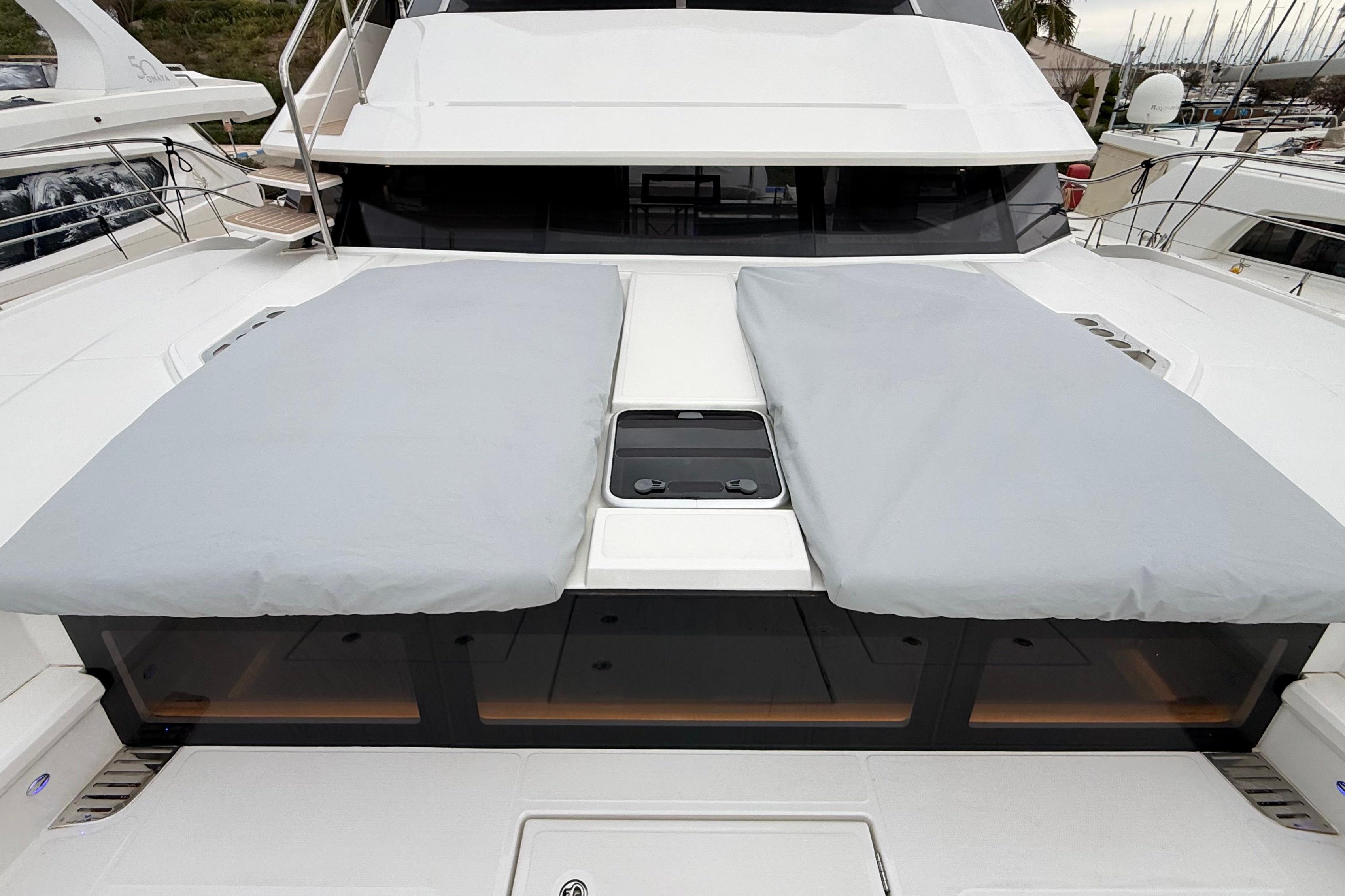 2025 Aquila 50 Yacht with covered sunbeds on deck, docked at marina.