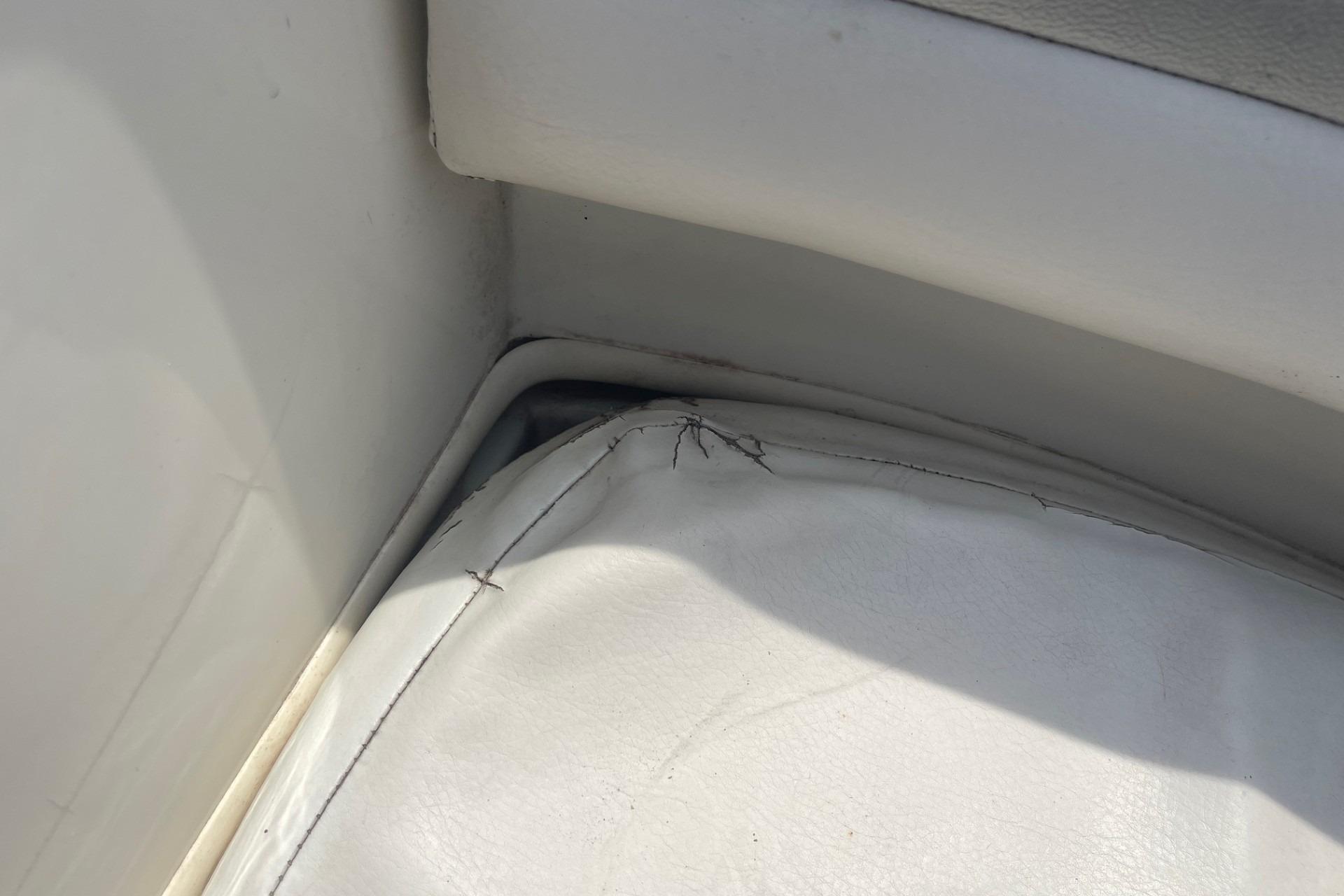 Torn upholstery on 2010 Sea Ray 230 Bow Rider Select boat seat corner.