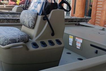 2026 Tracker Grizzly 1860 CC boat interior with steering console and cushioned seating.