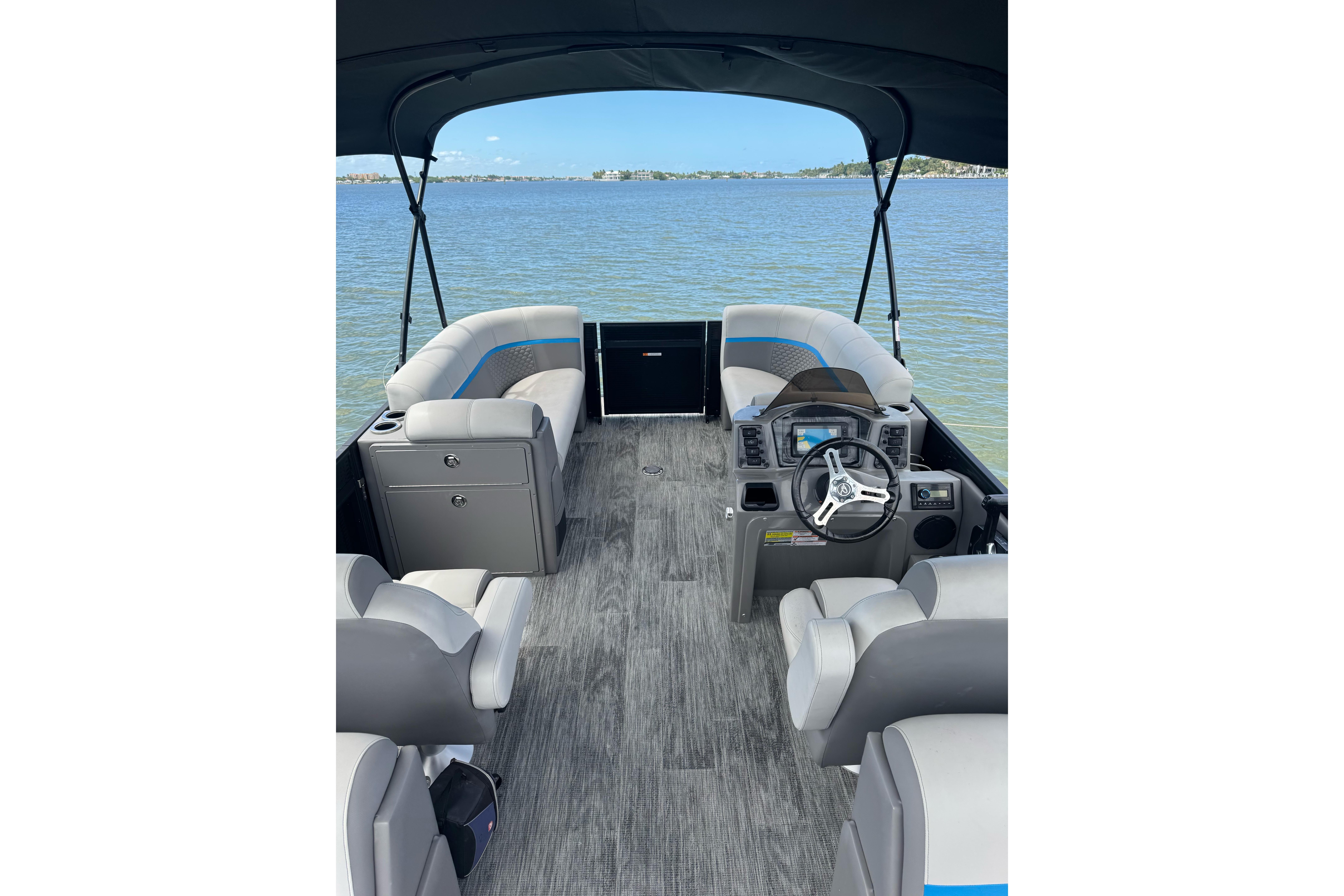 Interior of 2022 Qwest Edge 820 CTR pontoon boat on a calm lake.