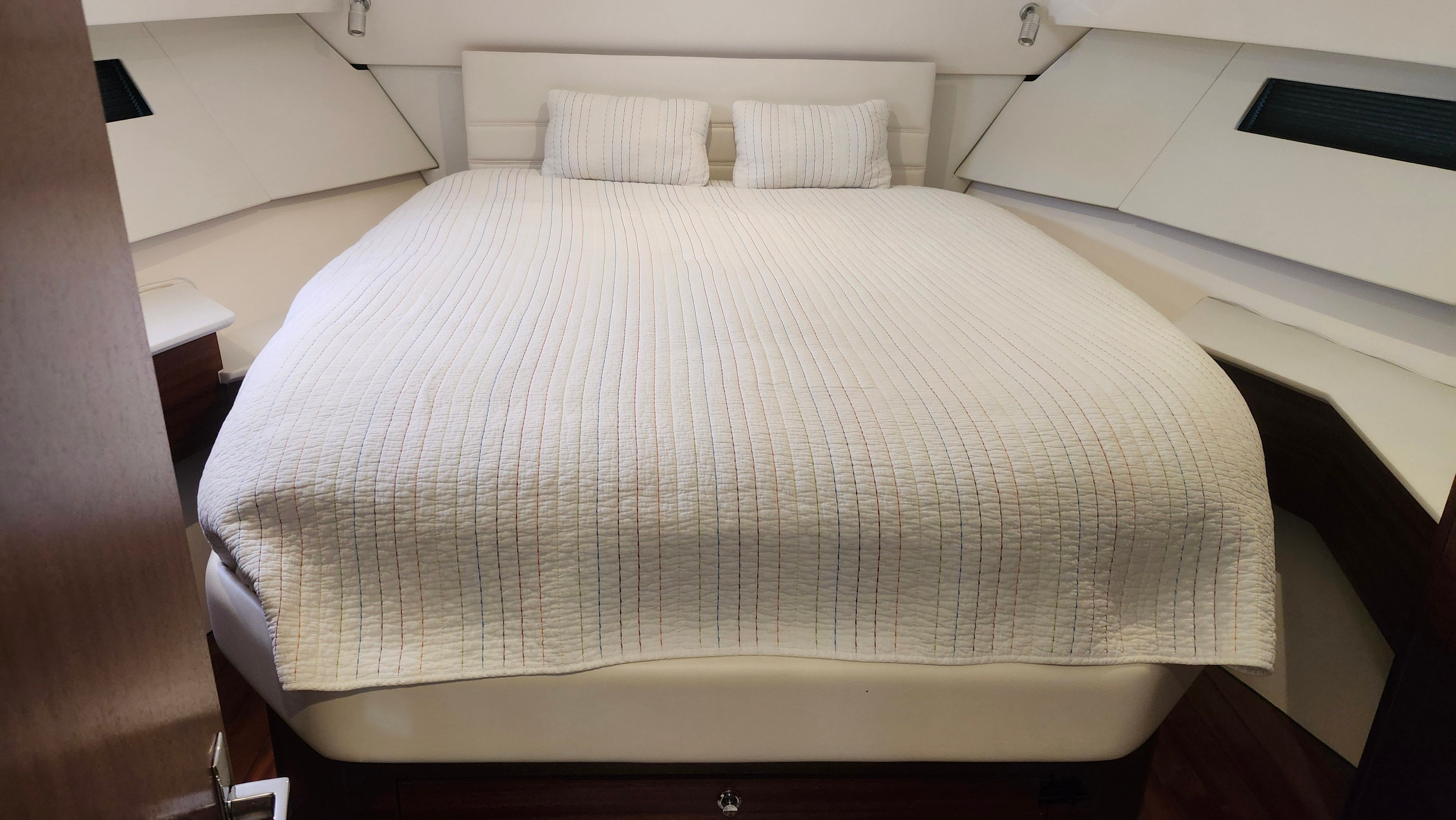 The image shows a cozy bedroom with a large bed and two pillows.