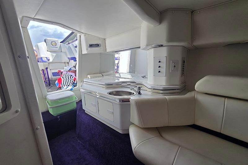 Interior of a 2004 Fountain 38 Lightning boat with white seating and compact kitchenette.