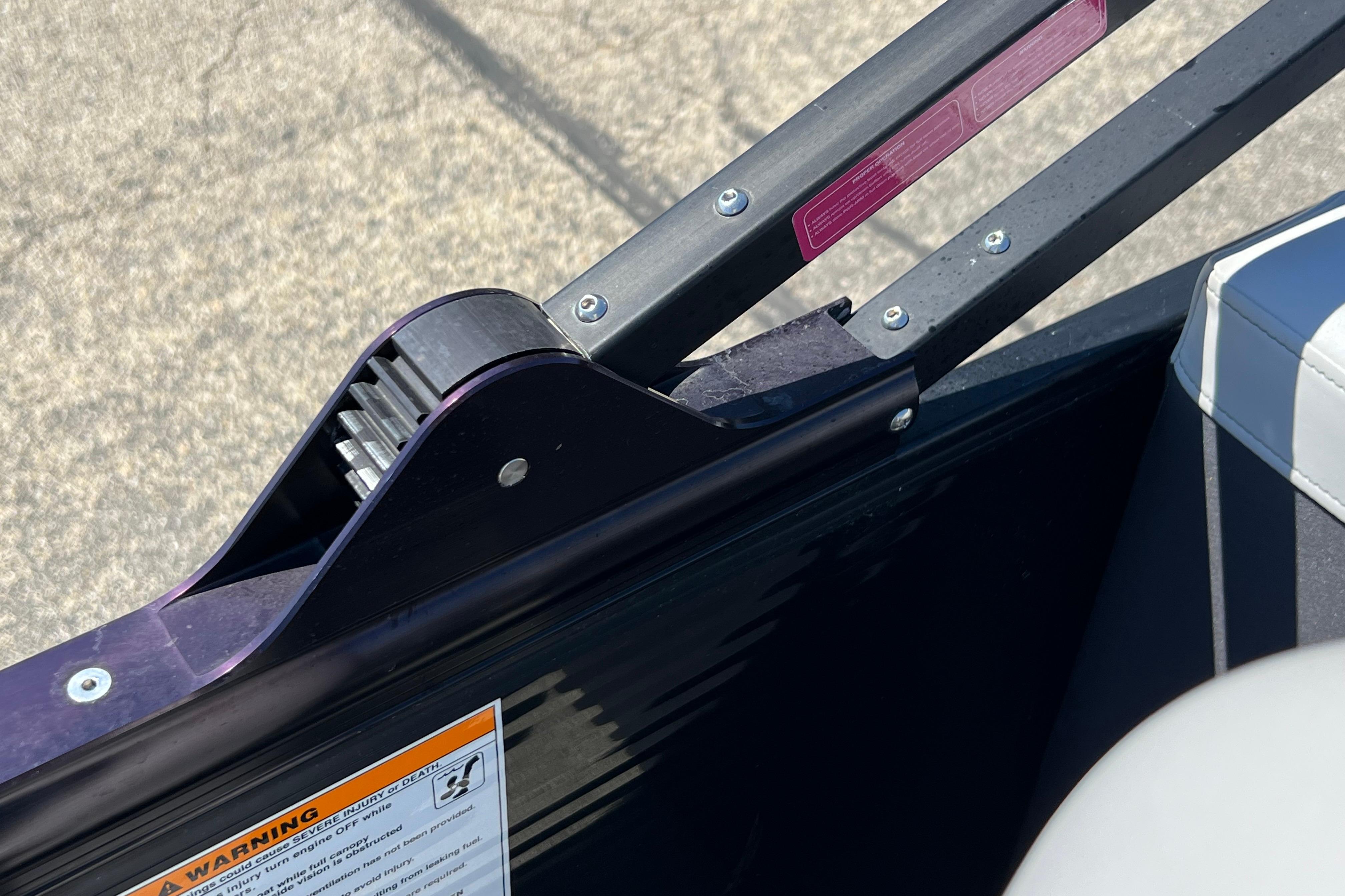 Close-up of 2023 Godfrey Monaco 235 SB boat railing and warning label.