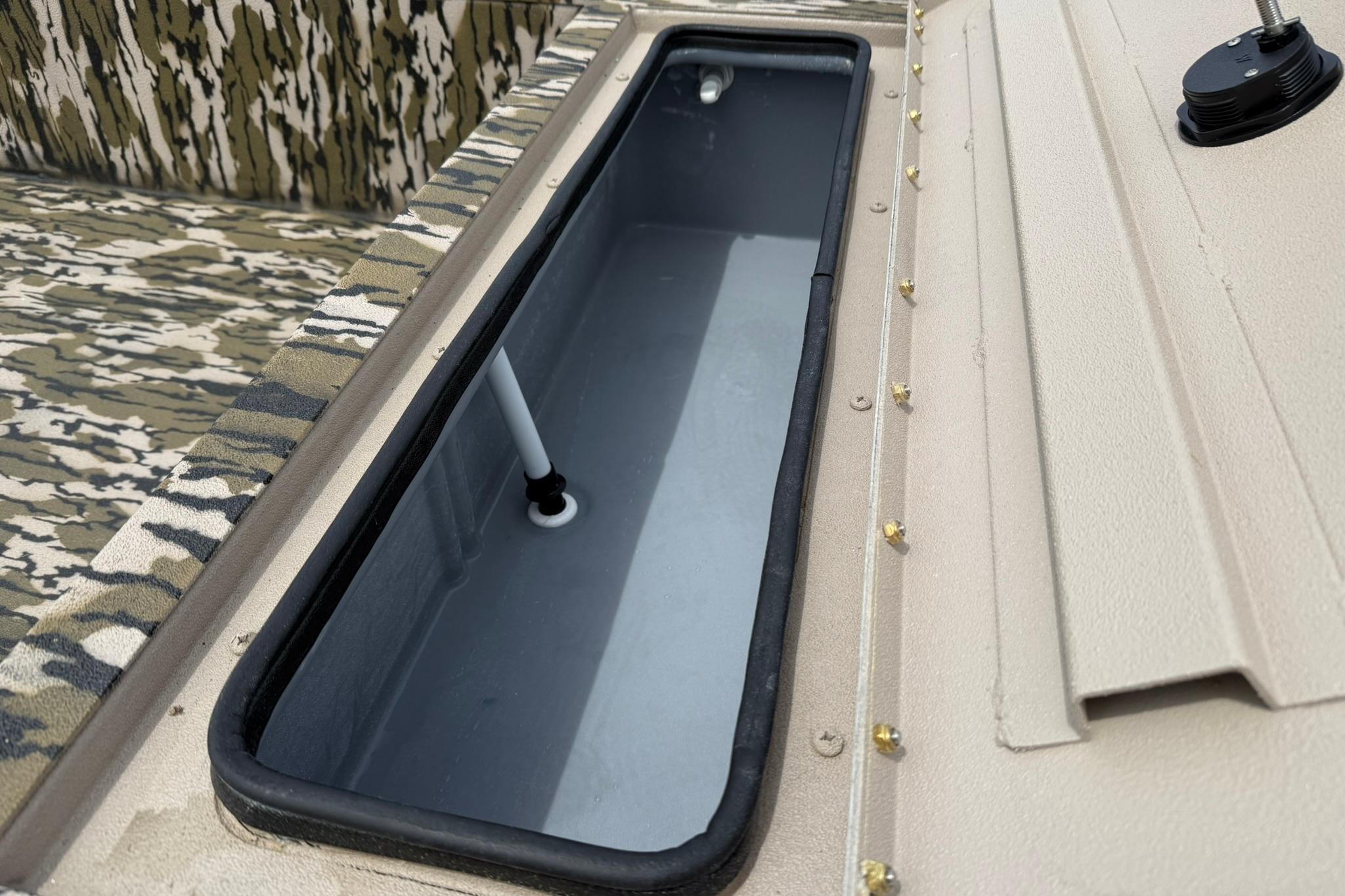 2026 Avid 16 Commander boat interior with camouflage seating and storage compartment.