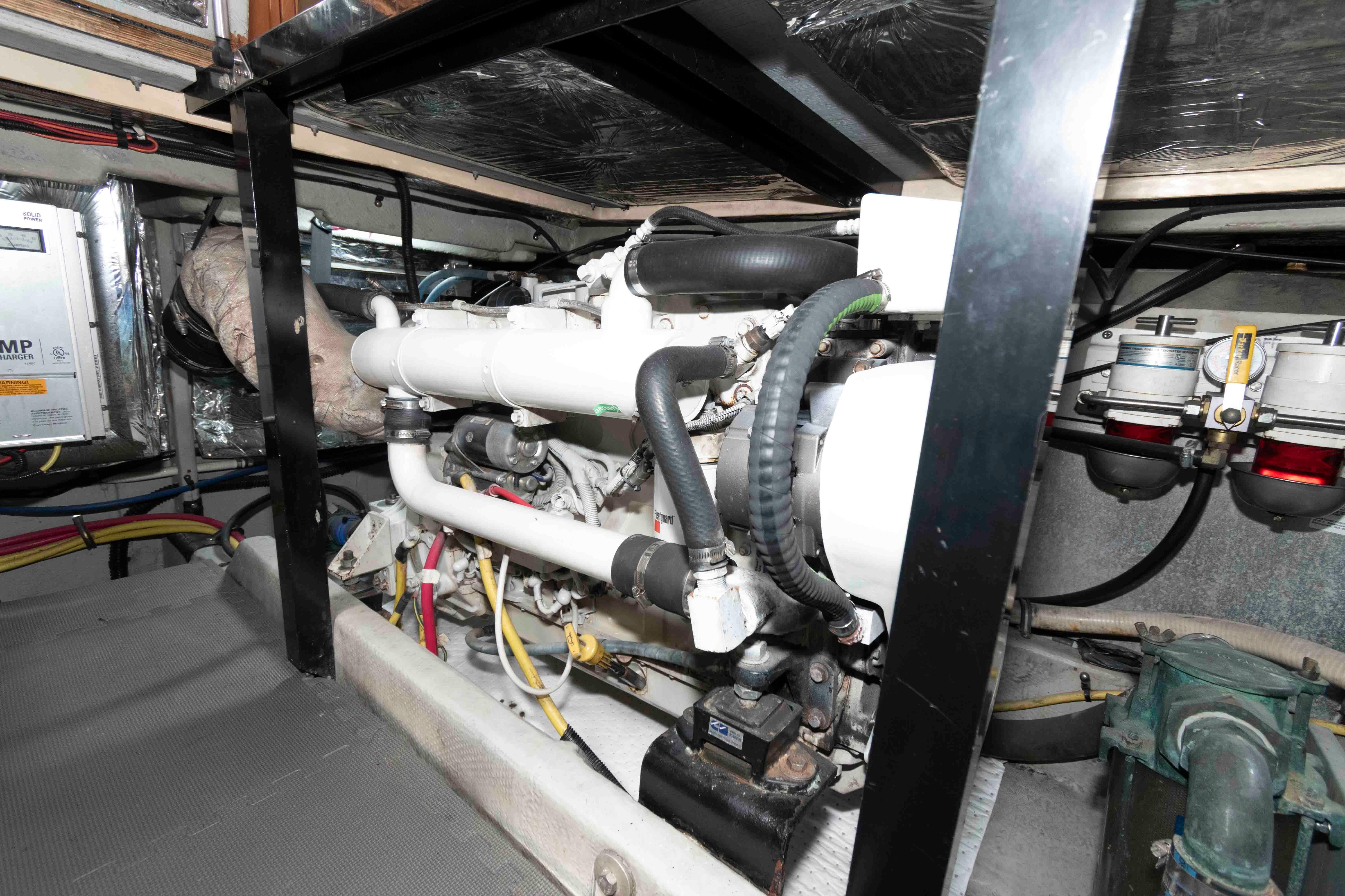 Engine room of a 2004 Meridian 459 Motoryacht, showcasing mechanical components and piping.