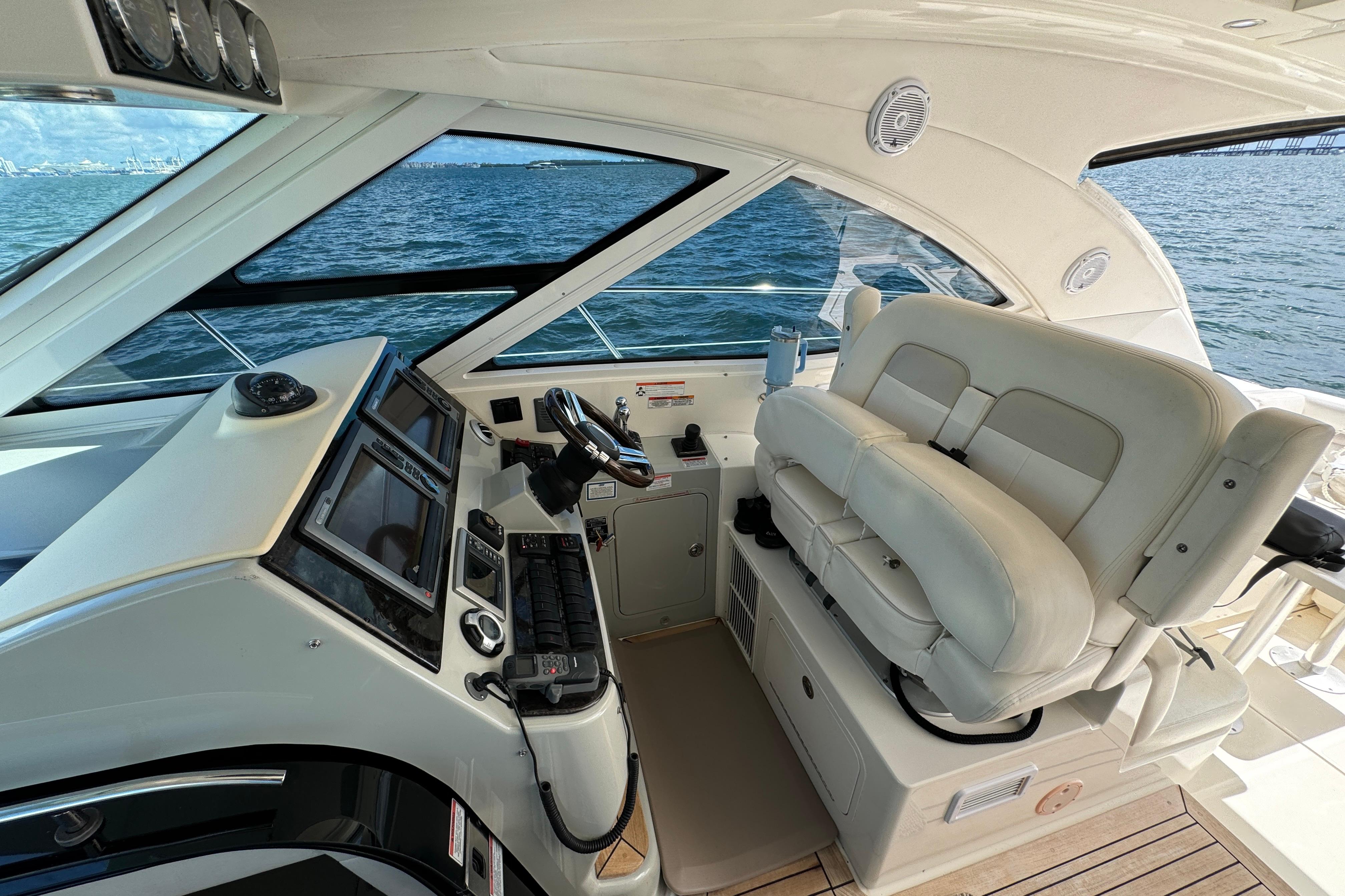 2011 Sea Ray 470 Sundancer helm with dual seats and navigation controls, overlooking ocean.