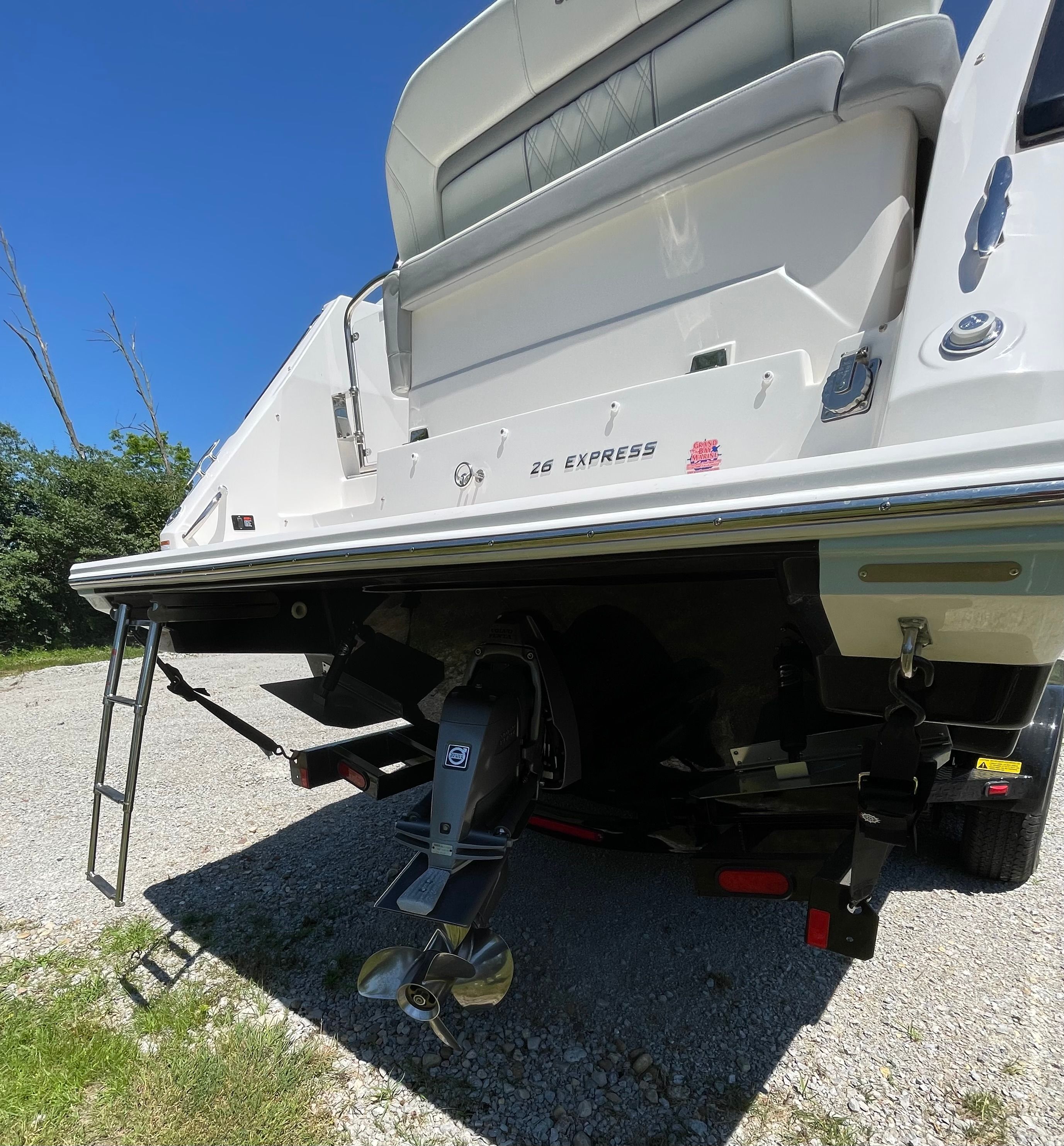 Rear view of a 2022 Regal 26 Express boat on gravel.