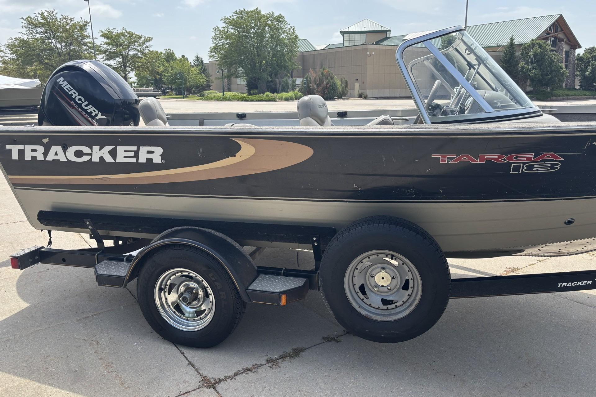 1999 Tracker Targa 18 boat on trailer with Mercury outboard motor, parked outdoors.