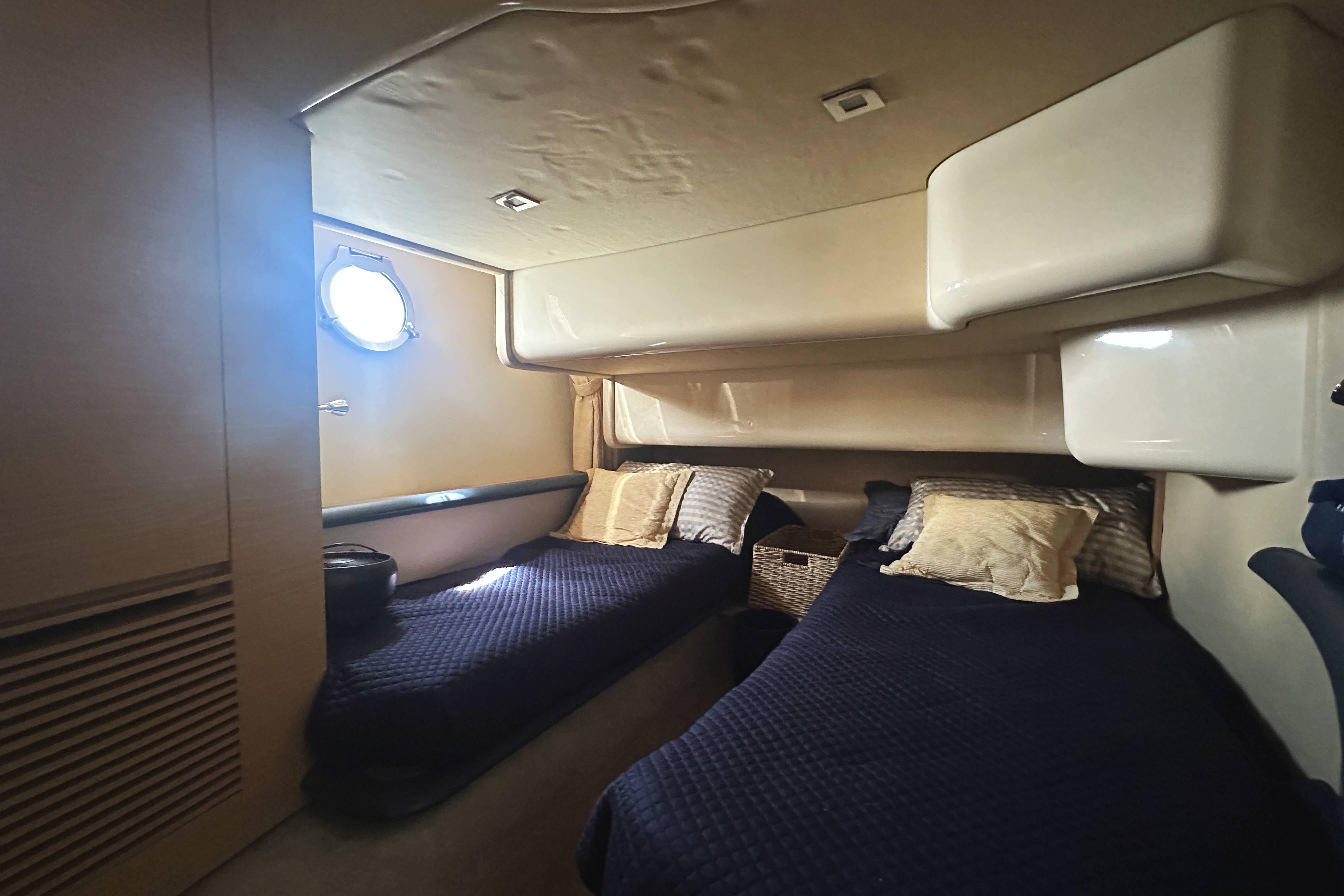 2007 Azimut 43 yacht cabin with twin beds and porthole window.