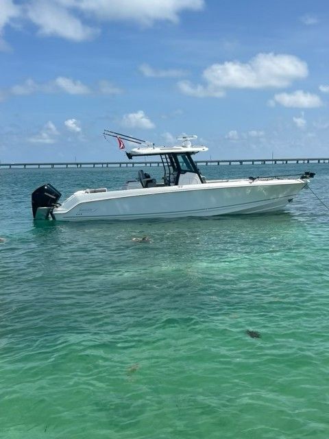 2023 Boston Whaler 330 Outrage on calm waters near a bridge.