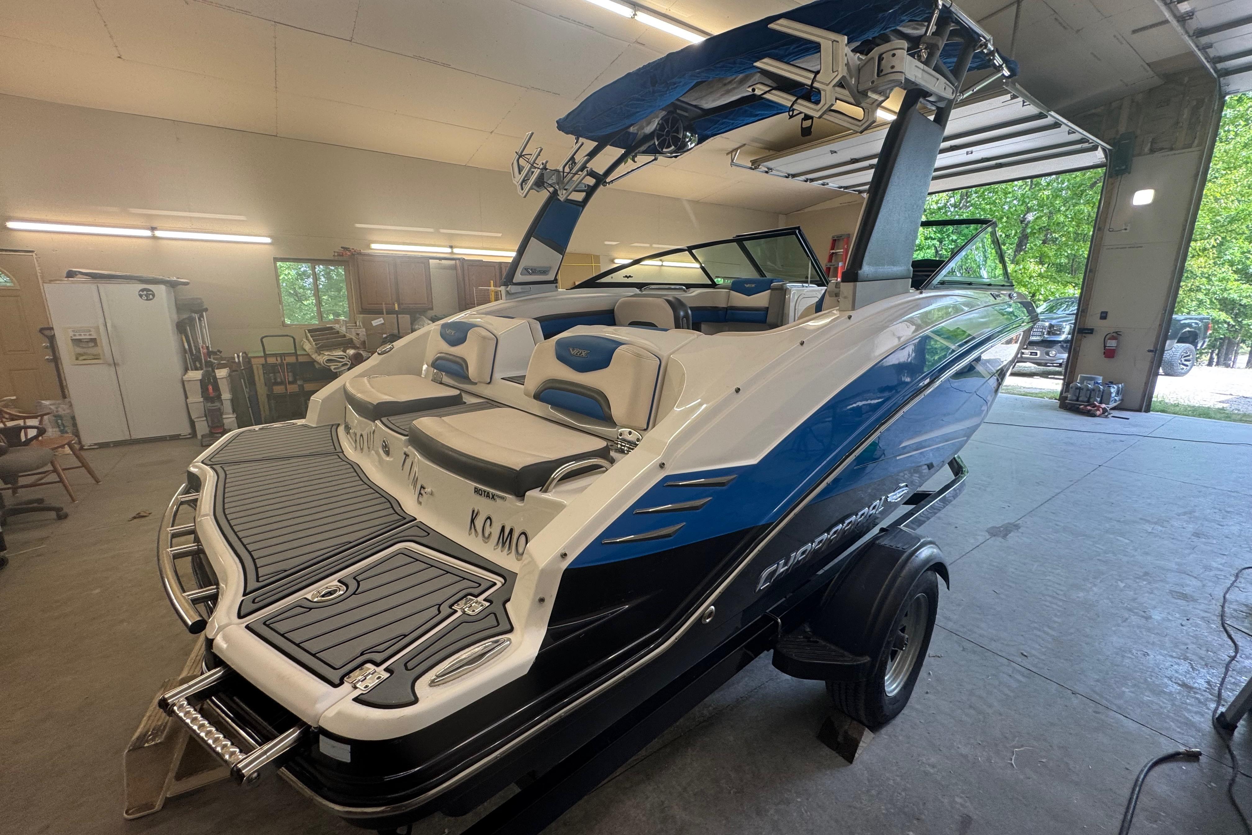 2017 Chaparral Vortex 203 VRX boat in garage, featuring sleek design and blue accents.