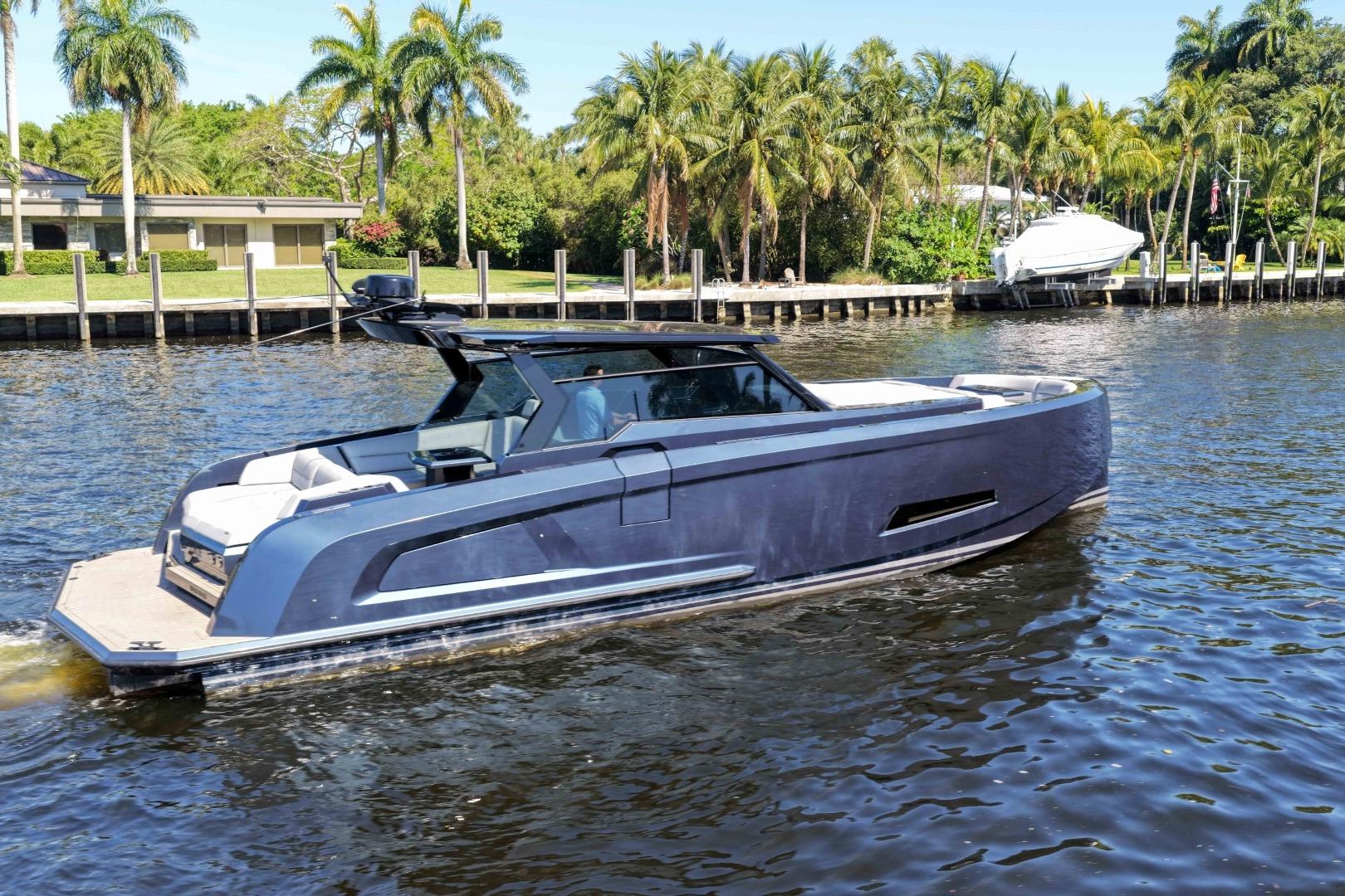 Luxury 2022 Vanquish Yachts VQ45 cruising on a scenic waterway with palm trees.