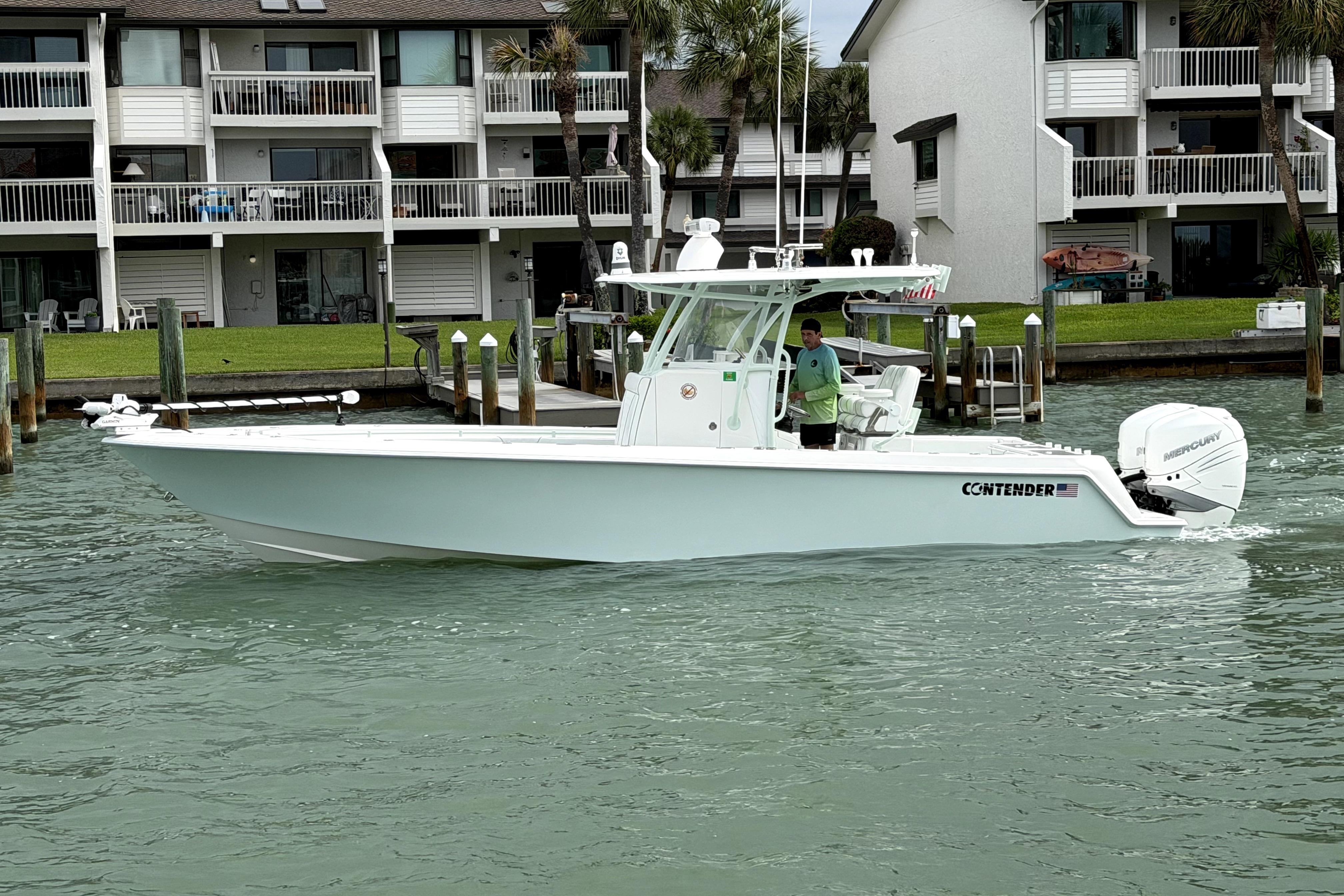 2019 Contender 30 ST boat cruising near waterfront homes.