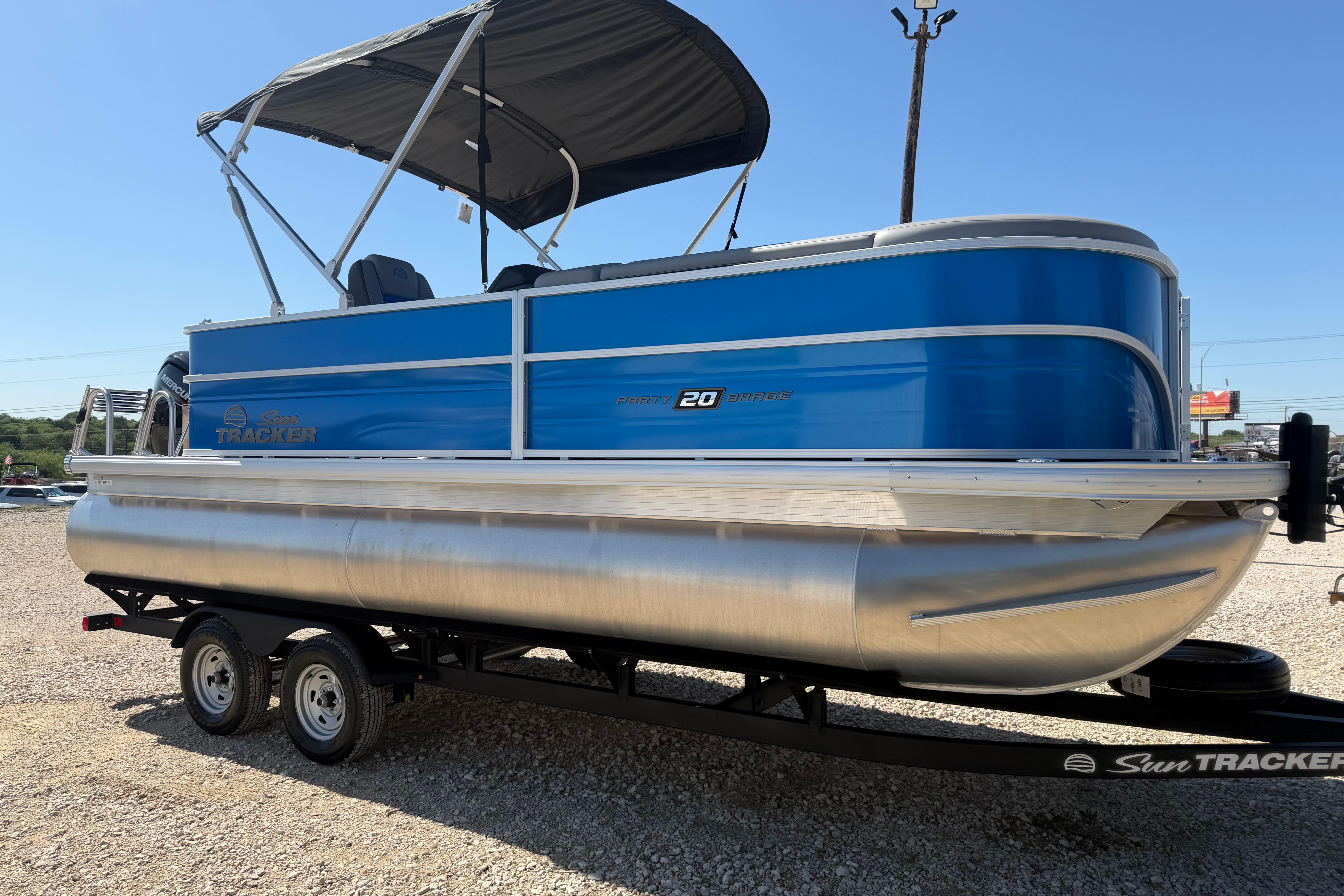 2026 Sun Tracker Party Barge 20 DLX pontoon boat with blue exterior on trailer.