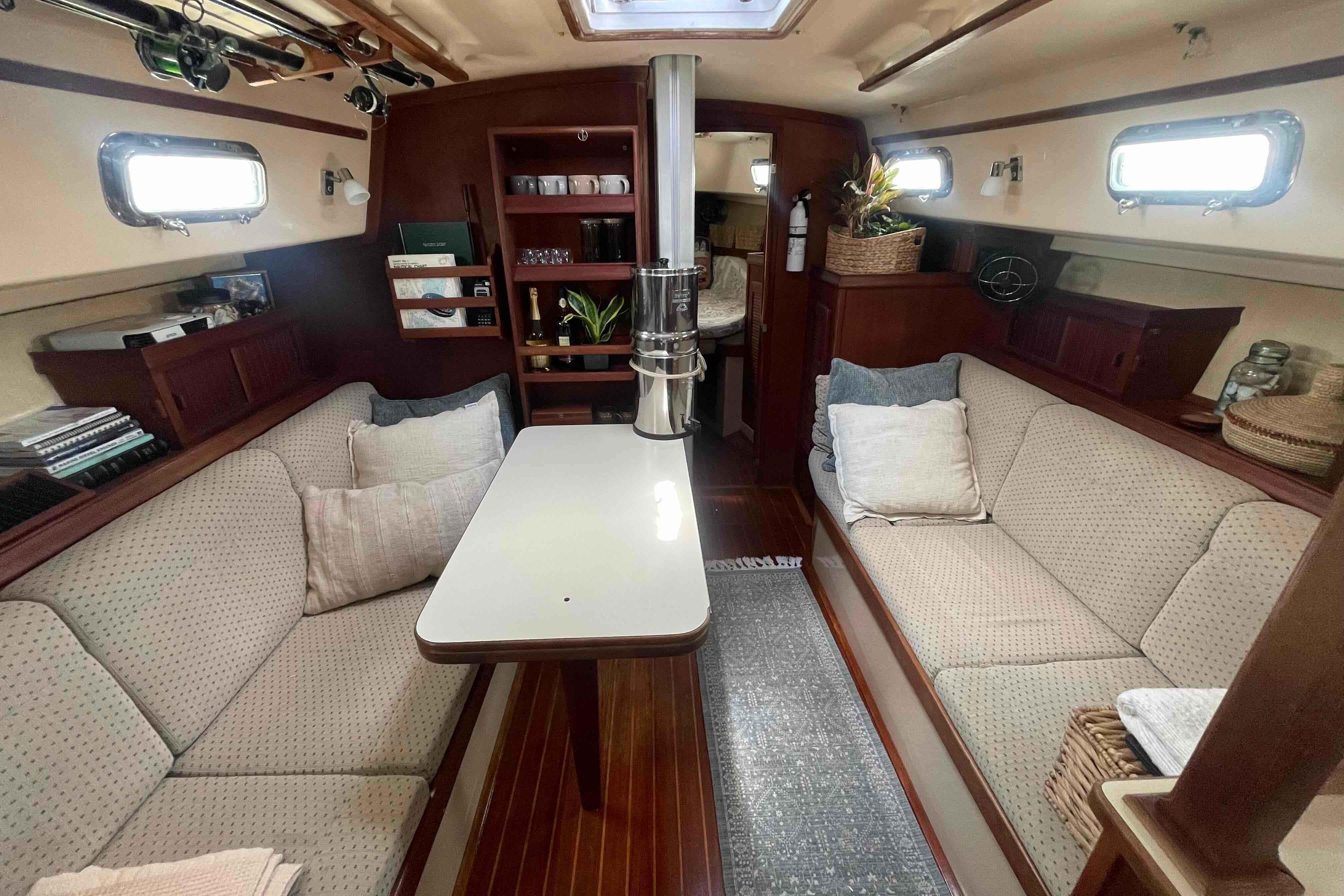 Interior of 1989 Island Packet 35 sailboat with cozy seating and elegant wood finish.