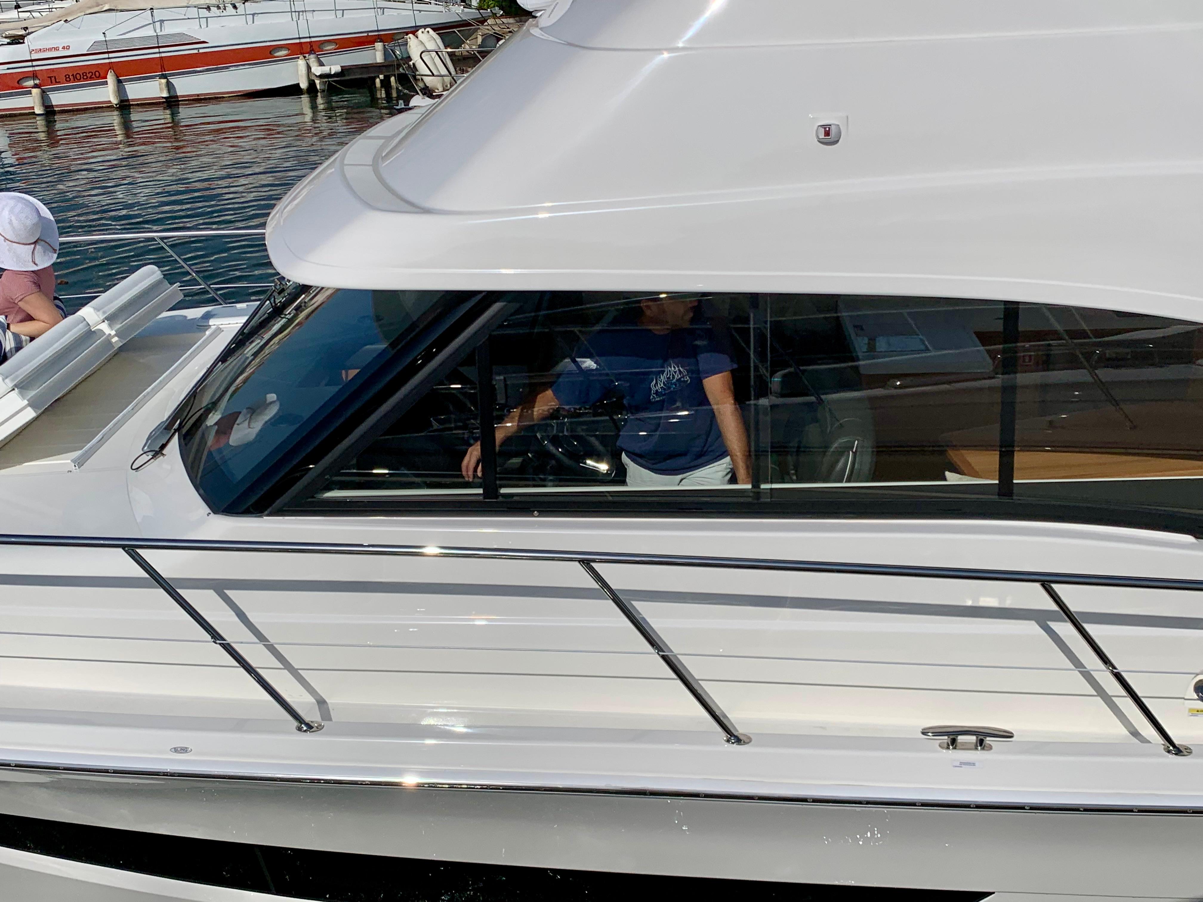 2019 Riviera 39 Sports Motor Yacht docked, side view with visible cabin and railing.
