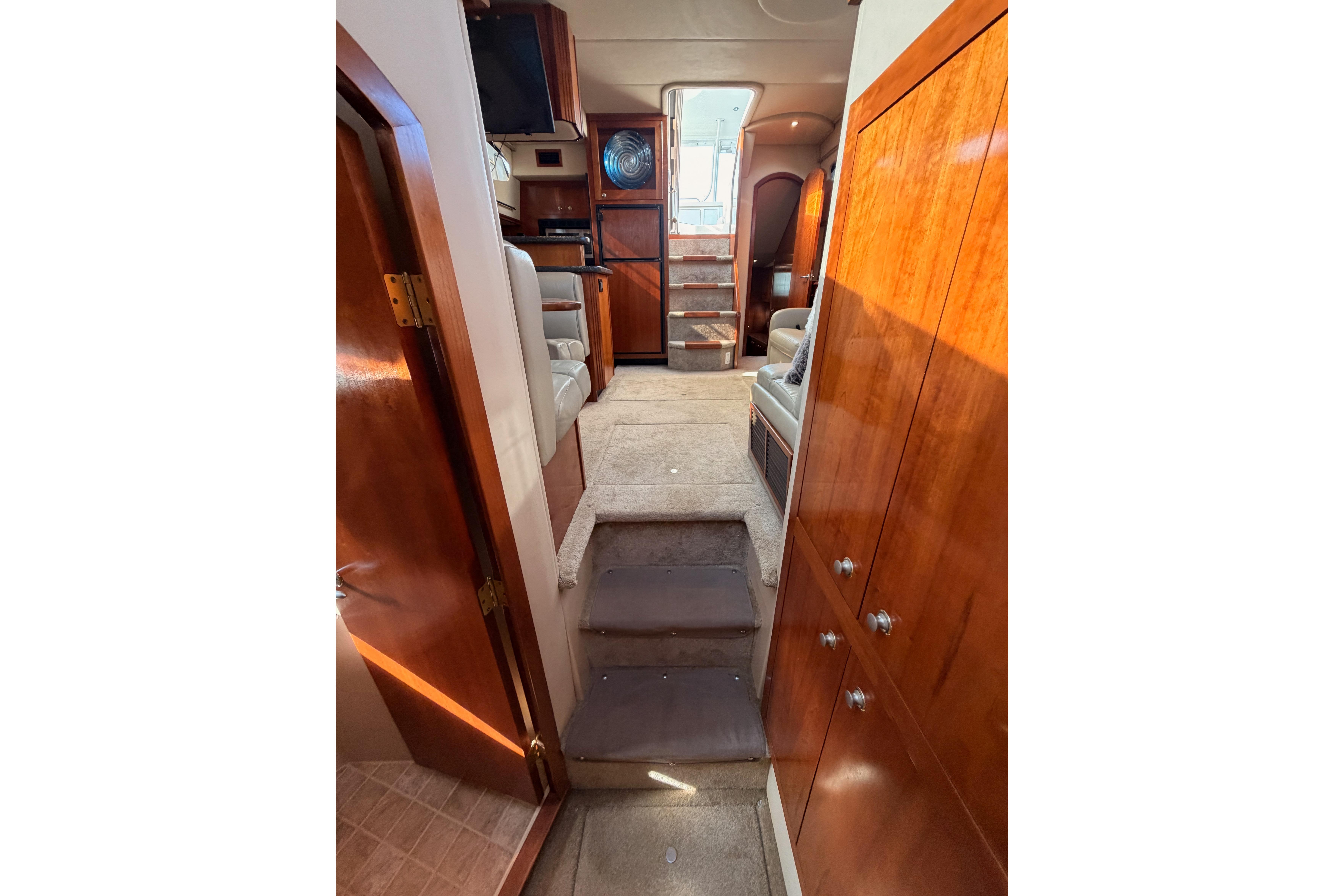 Interior of 2005 Cruisers Yachts 405 Express Motoryacht with wood cabinetry and carpeted steps.