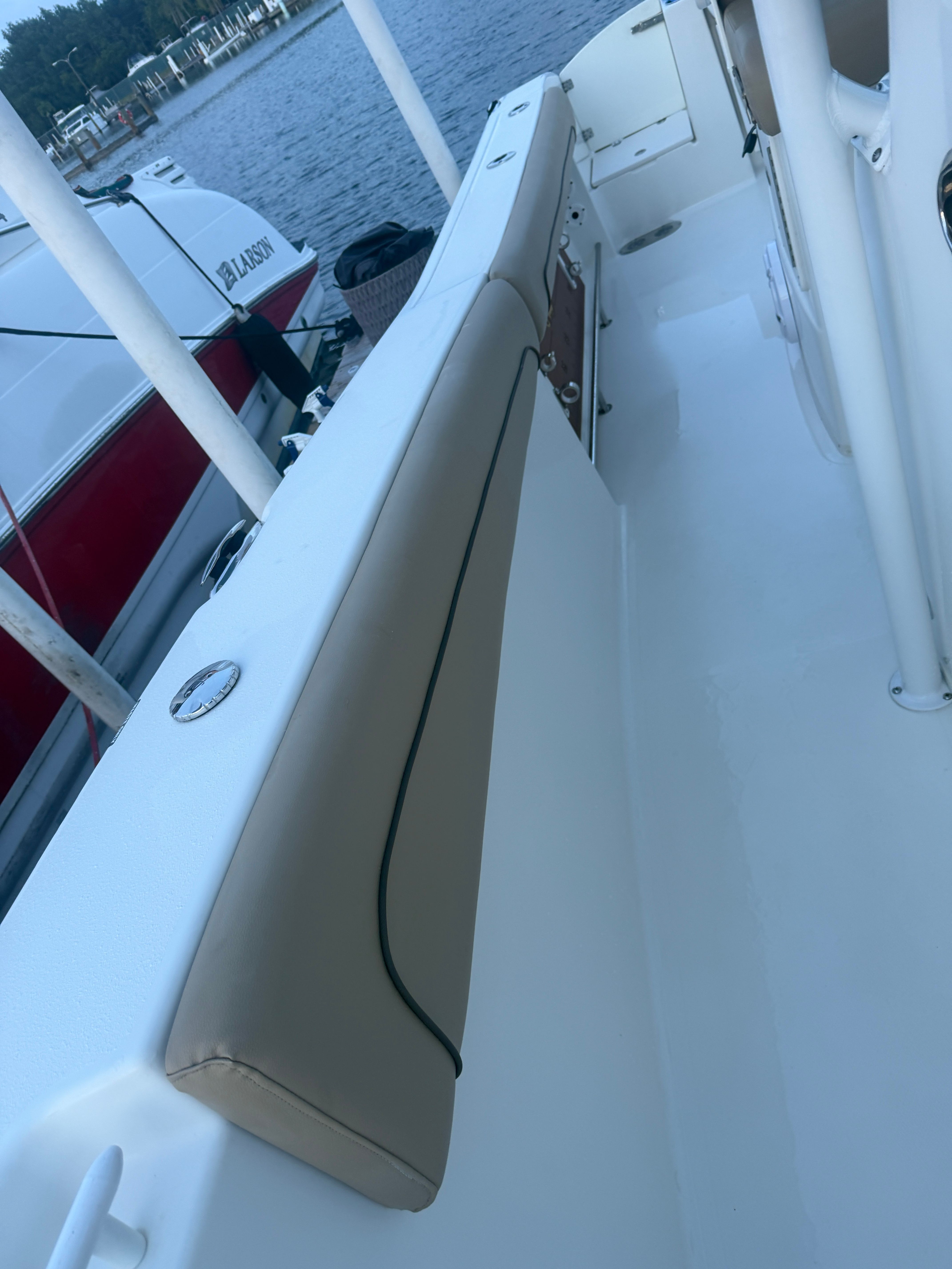 The image shows the deck of a 2019 NauticStar 28 XS boat with beige upholstery.