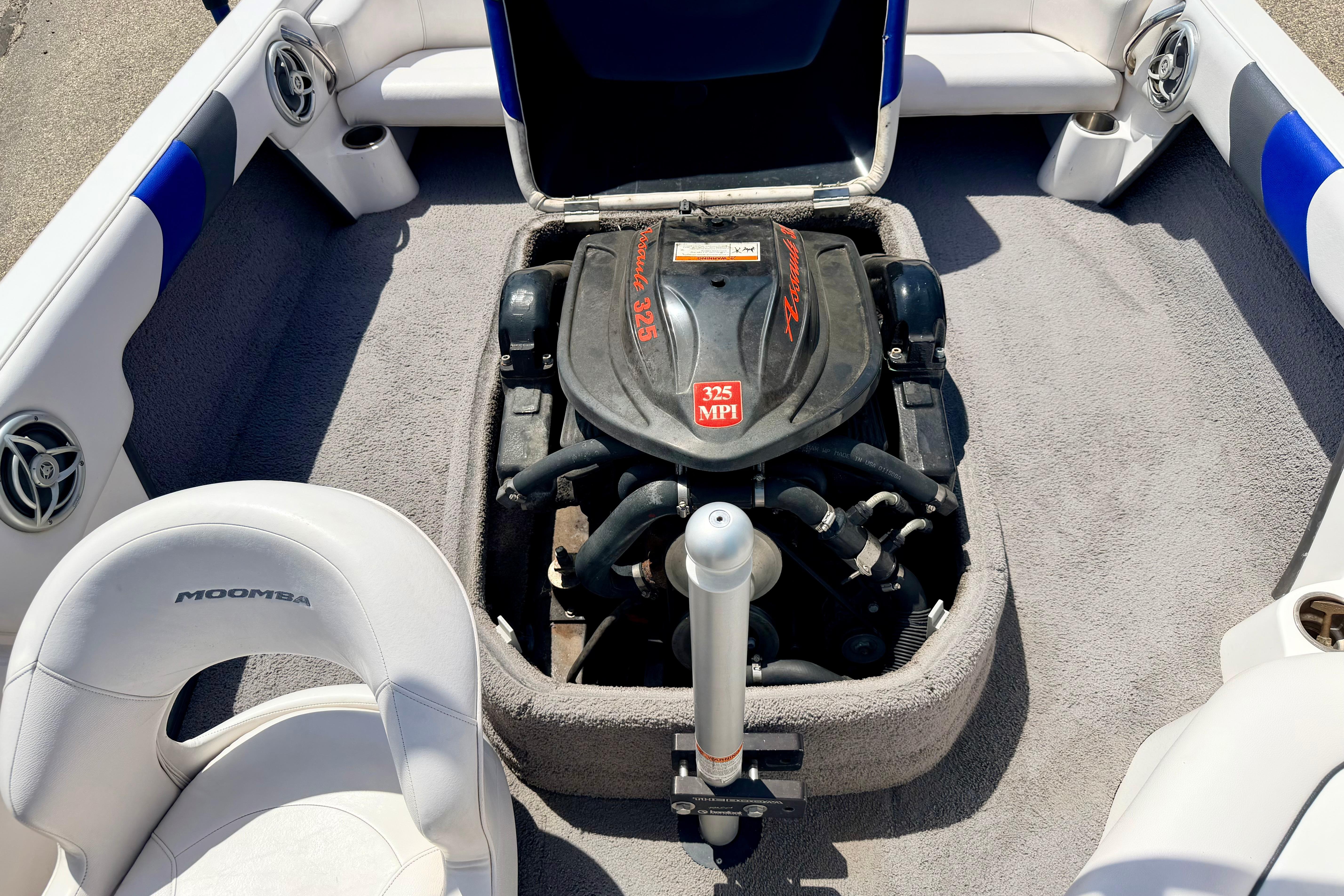 2008 Moomba Outback V boat engine compartment with 325 MPI engine, surrounded by white seating.