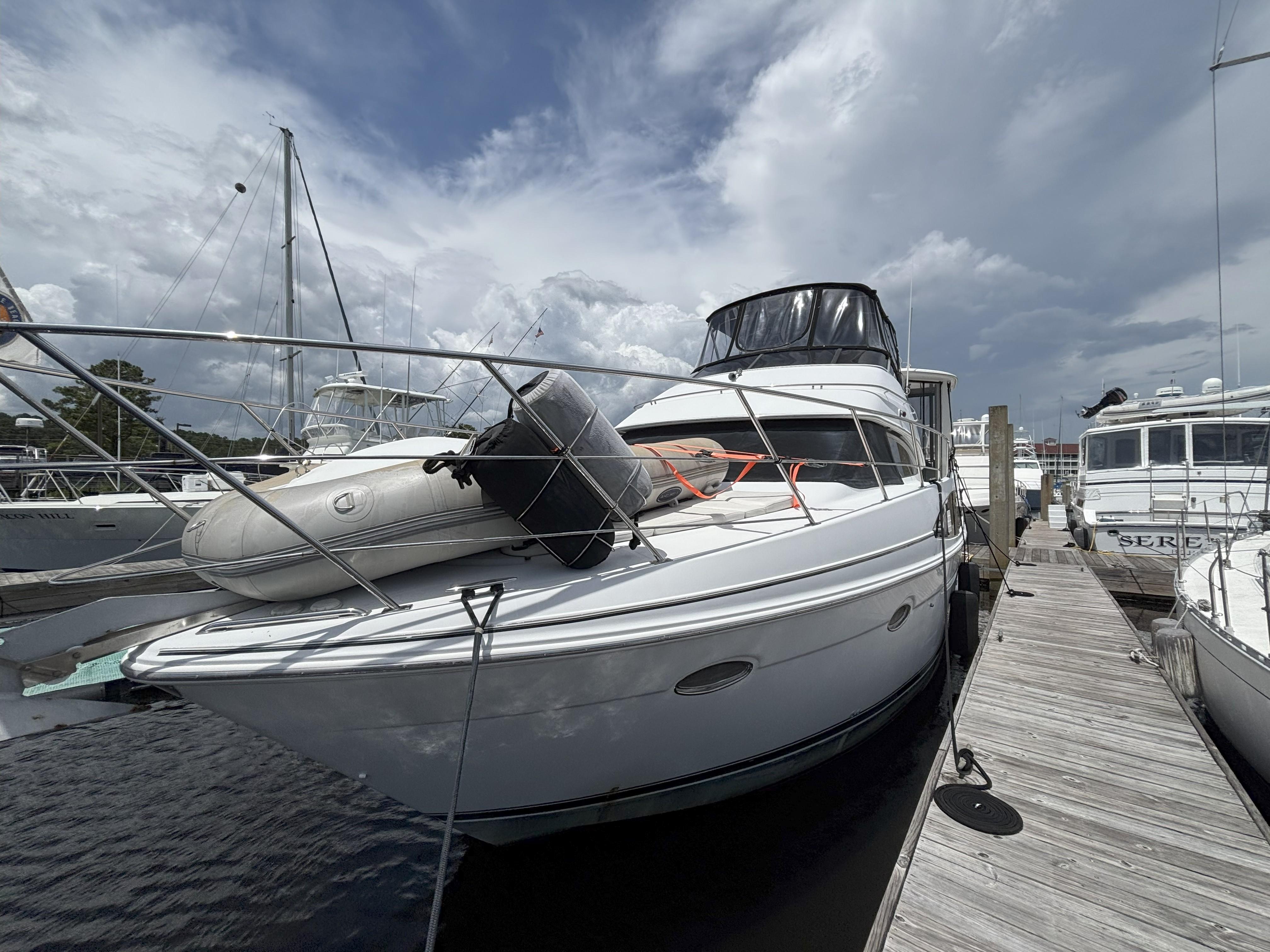 2001 Carver 396 Aft Cabin MY yacht docked with inflatable boat on deck.