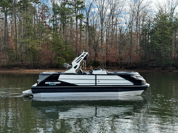2025 Montara Surf Boss 2.0 25 boat on a calm lake with forested background.