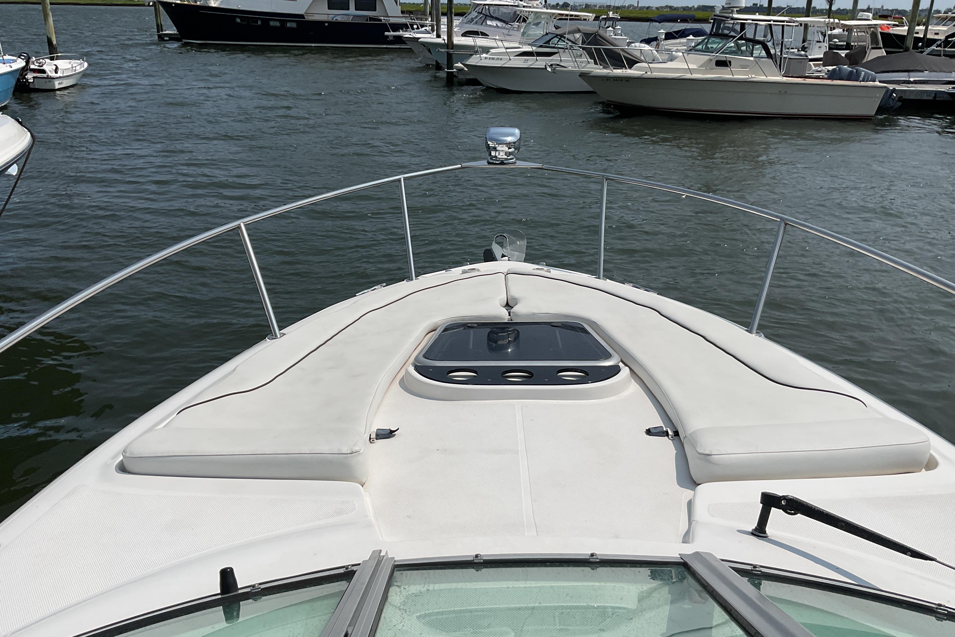 2013 Rinker 290 Express Cruiser docked in a marina, surrounded by other boats.