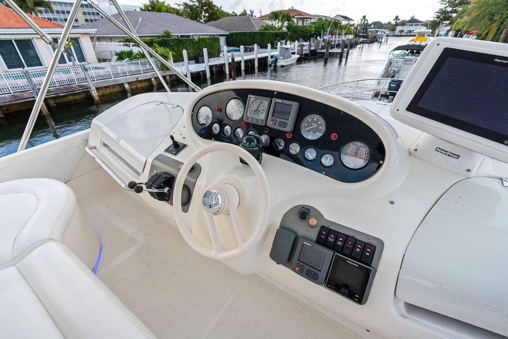 Cockpit of a 1999 Azimut 58 yacht with steering wheel and navigation instruments.
