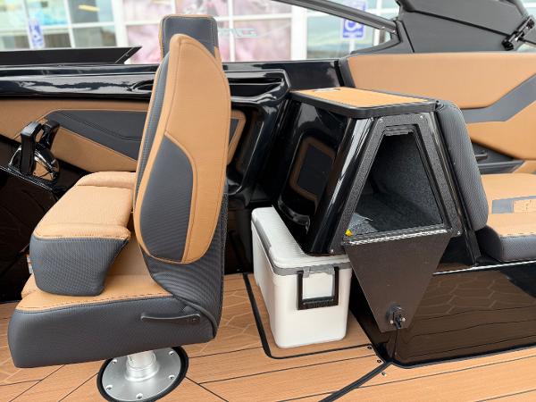 2025 Yamaha Boats 255XD interior with tan and black seating, modern design, and storage compartment.