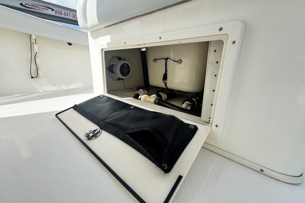 Open storage compartment on a 2018 Mako 284 Center Console boat, showcasing internal components.