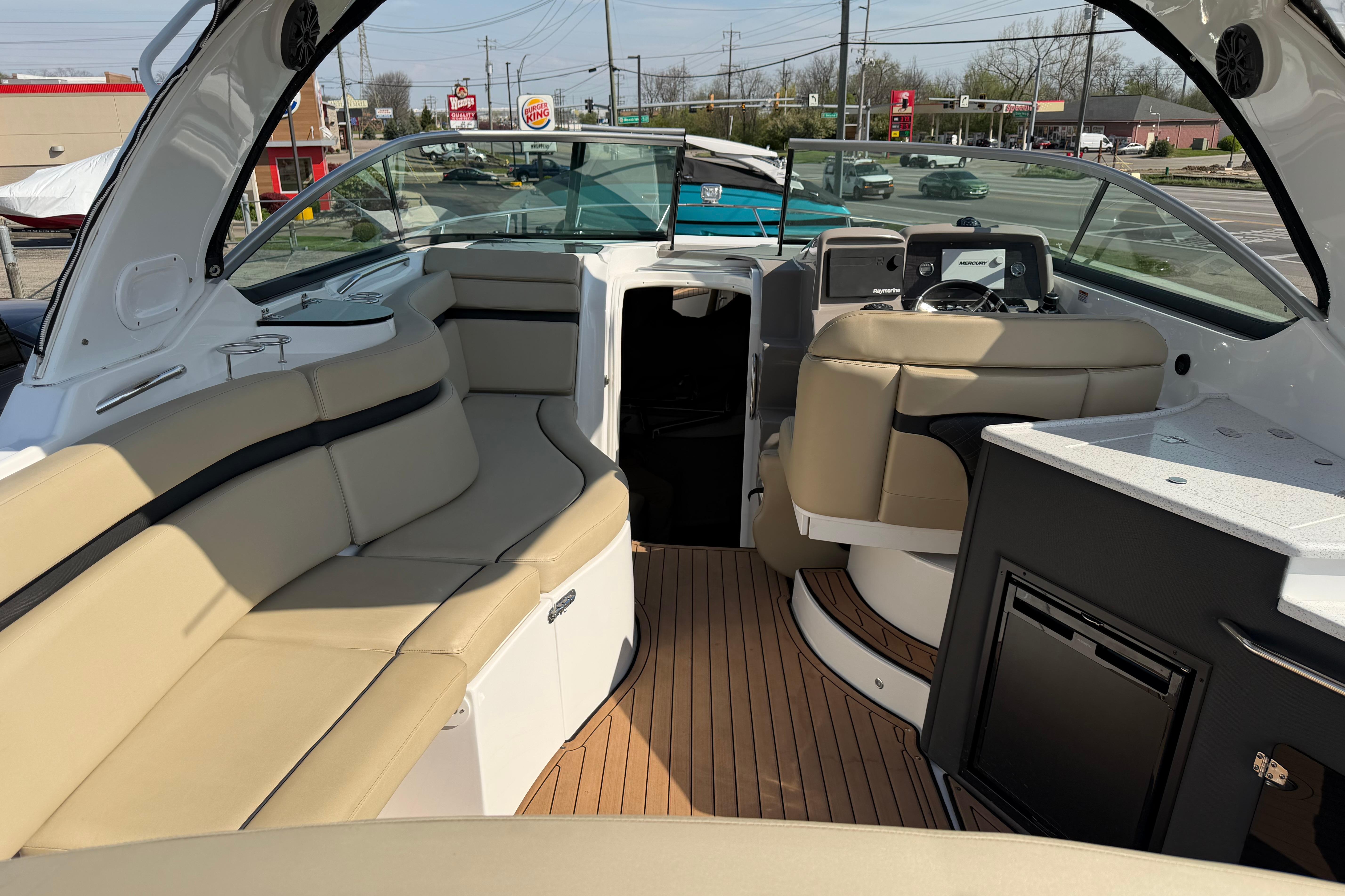 2019 Rinker EX 320 boat interior with beige seating and modern dashboard.