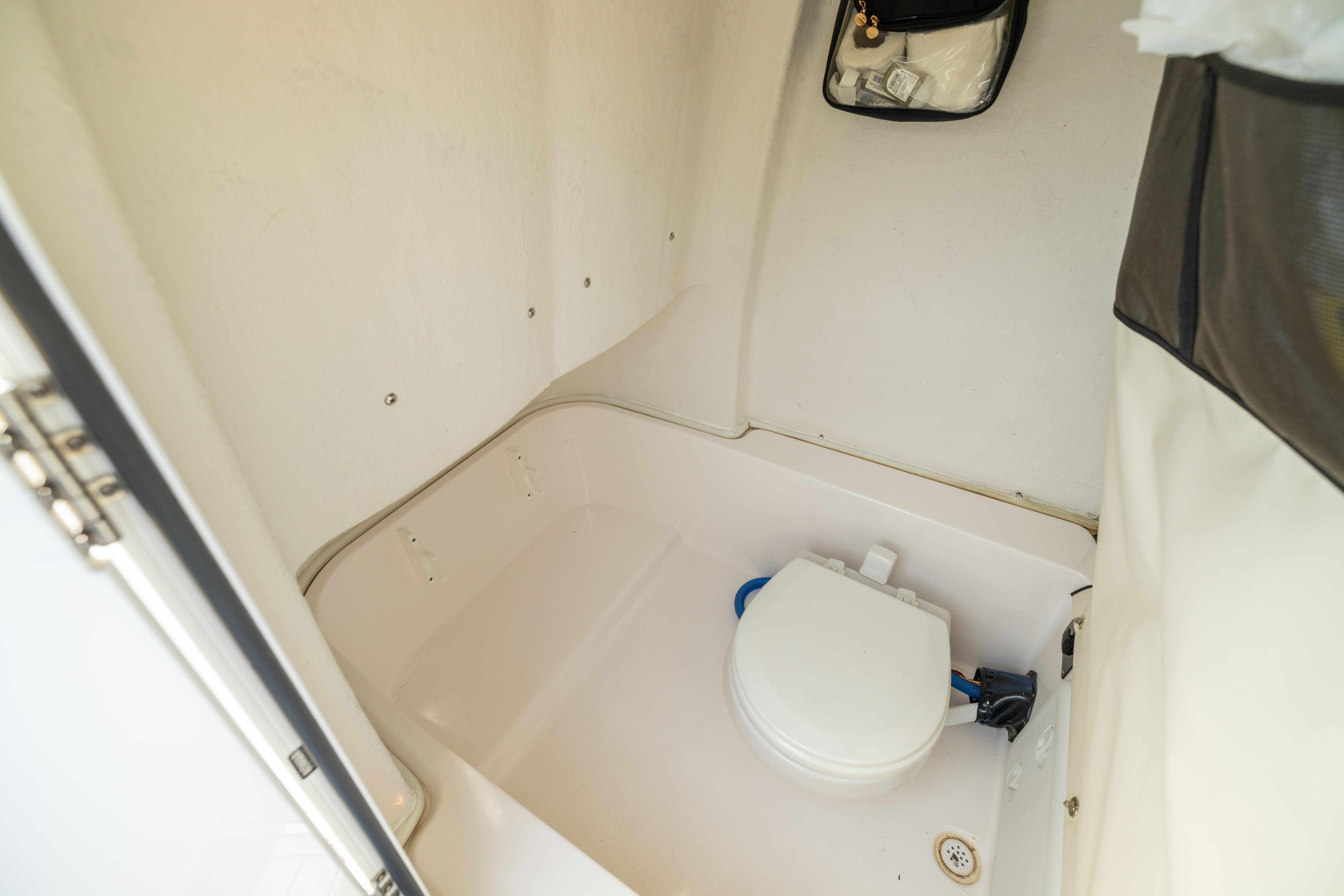 Interior view of 2023 Sea Fox 228 Commander boat's compact marine toilet area.
