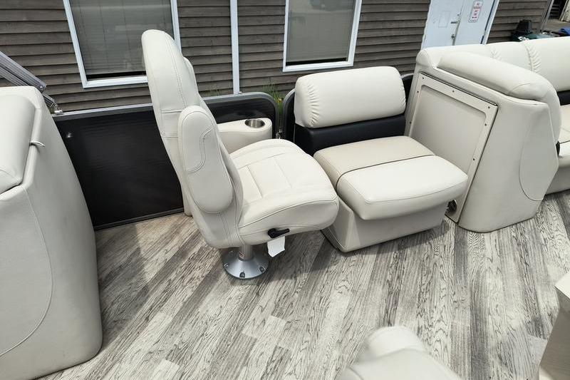 2017 Manitou 25 Oasis SE boat interior with beige seating and wood-style flooring.