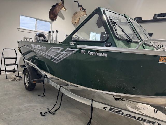 Green Hewescraft 180 Sportsman boat in garage, 2023 model.