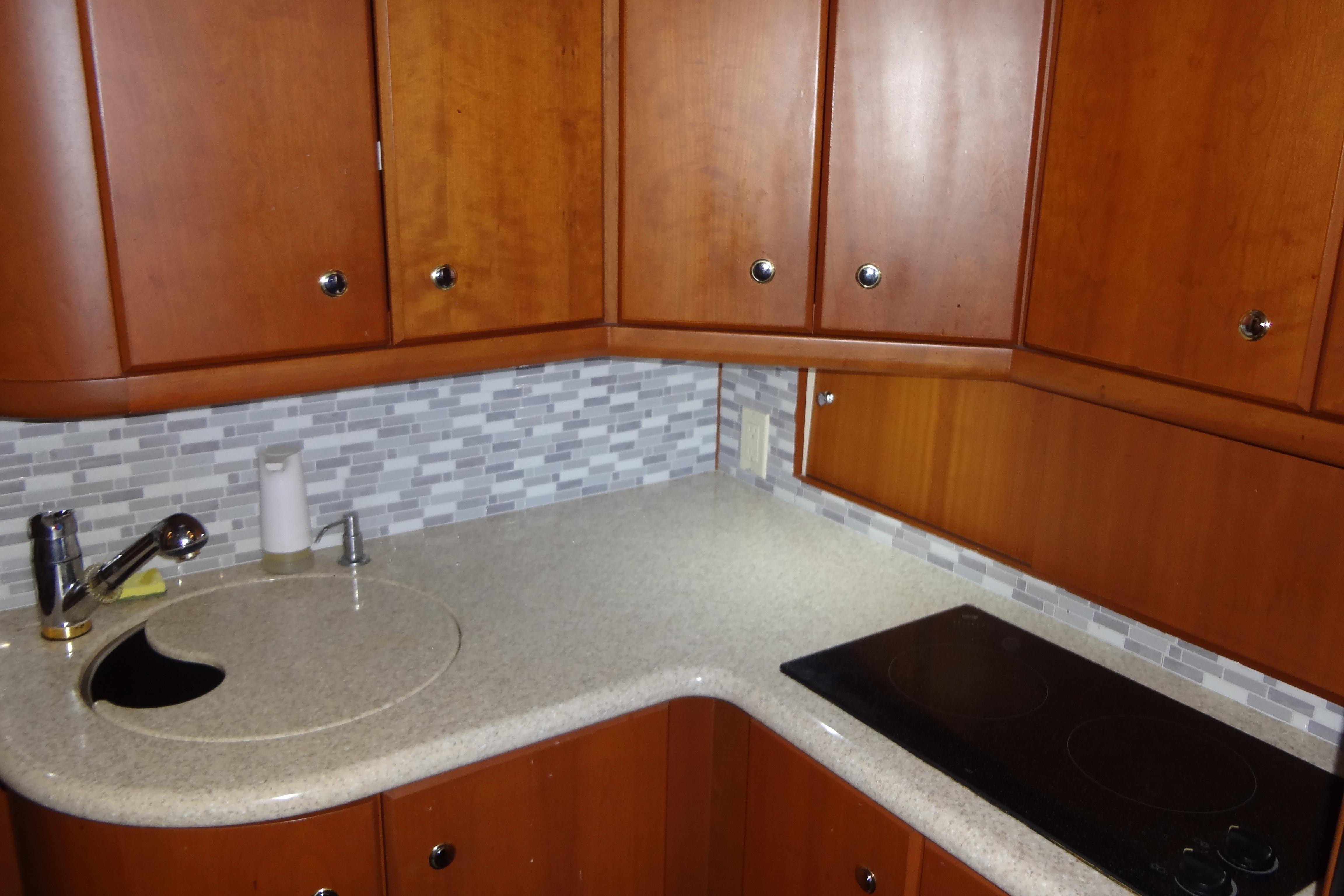 Luxurious 2005 Silverton 34 Convertible yacht kitchen with wood cabinets and modern appliances.