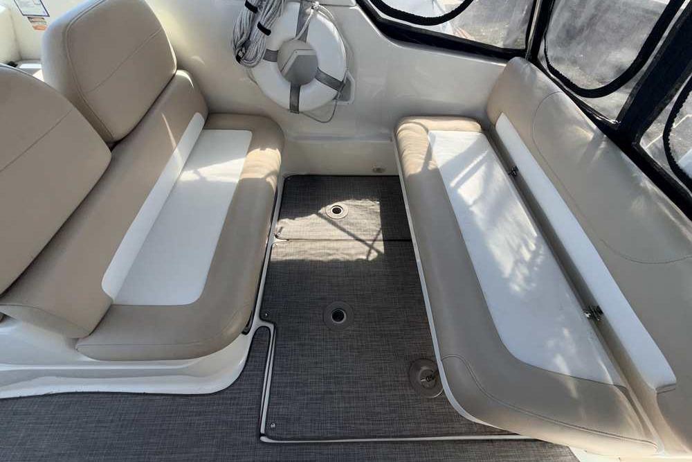 Interior seating of a 2001 Monterey 282 Cruiser boat with beige cushions.