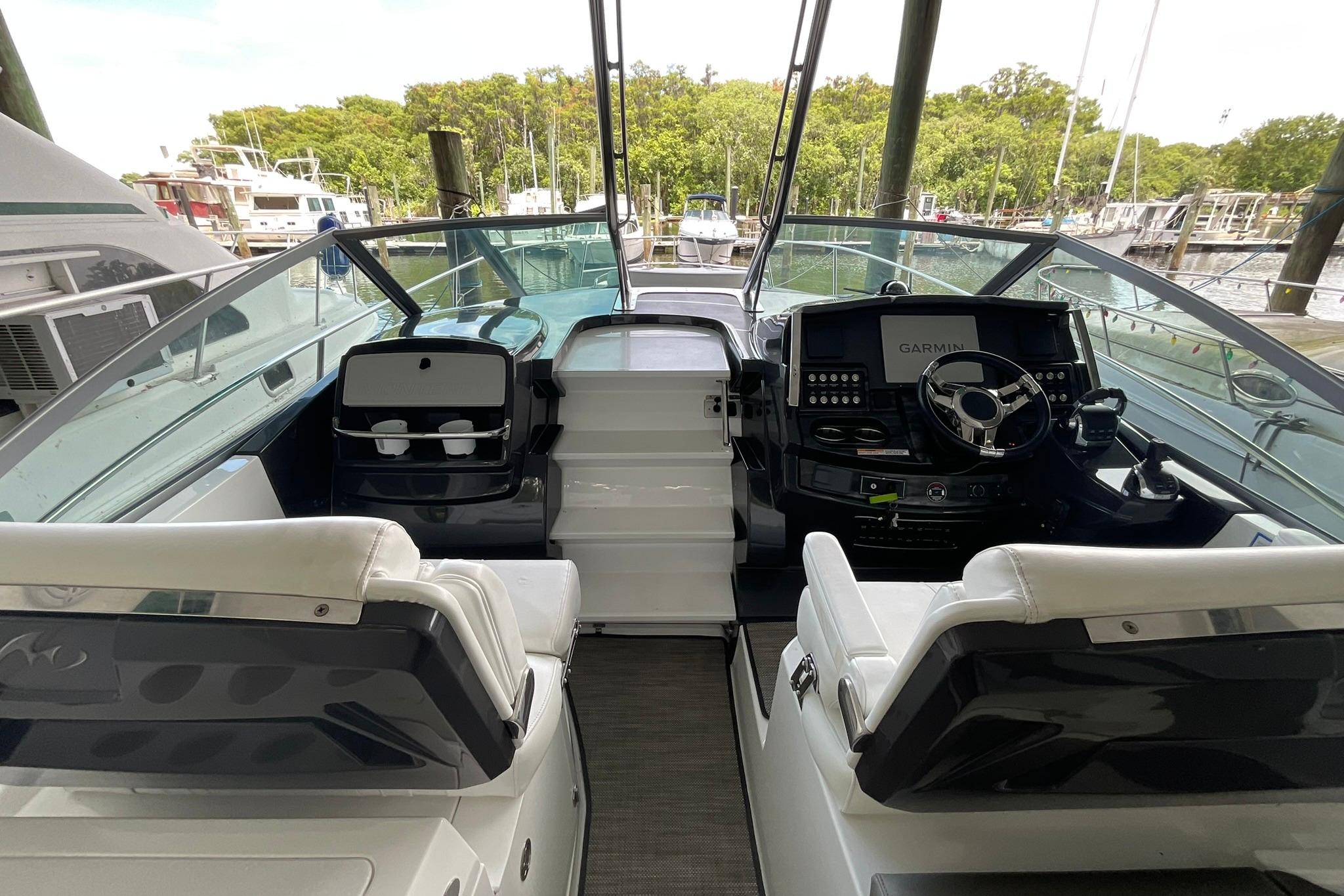 2019 Monterey 335 Sport Yacht cockpit with modern controls and seating at a marina.