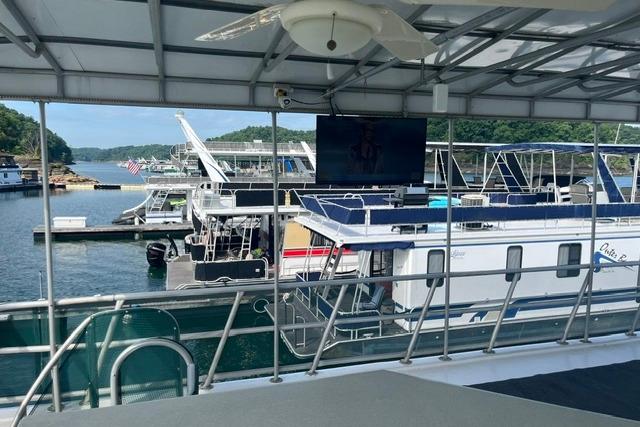 Houseboats docked at a marina, featuring a 1992 Lakeview model, under a covered deck.