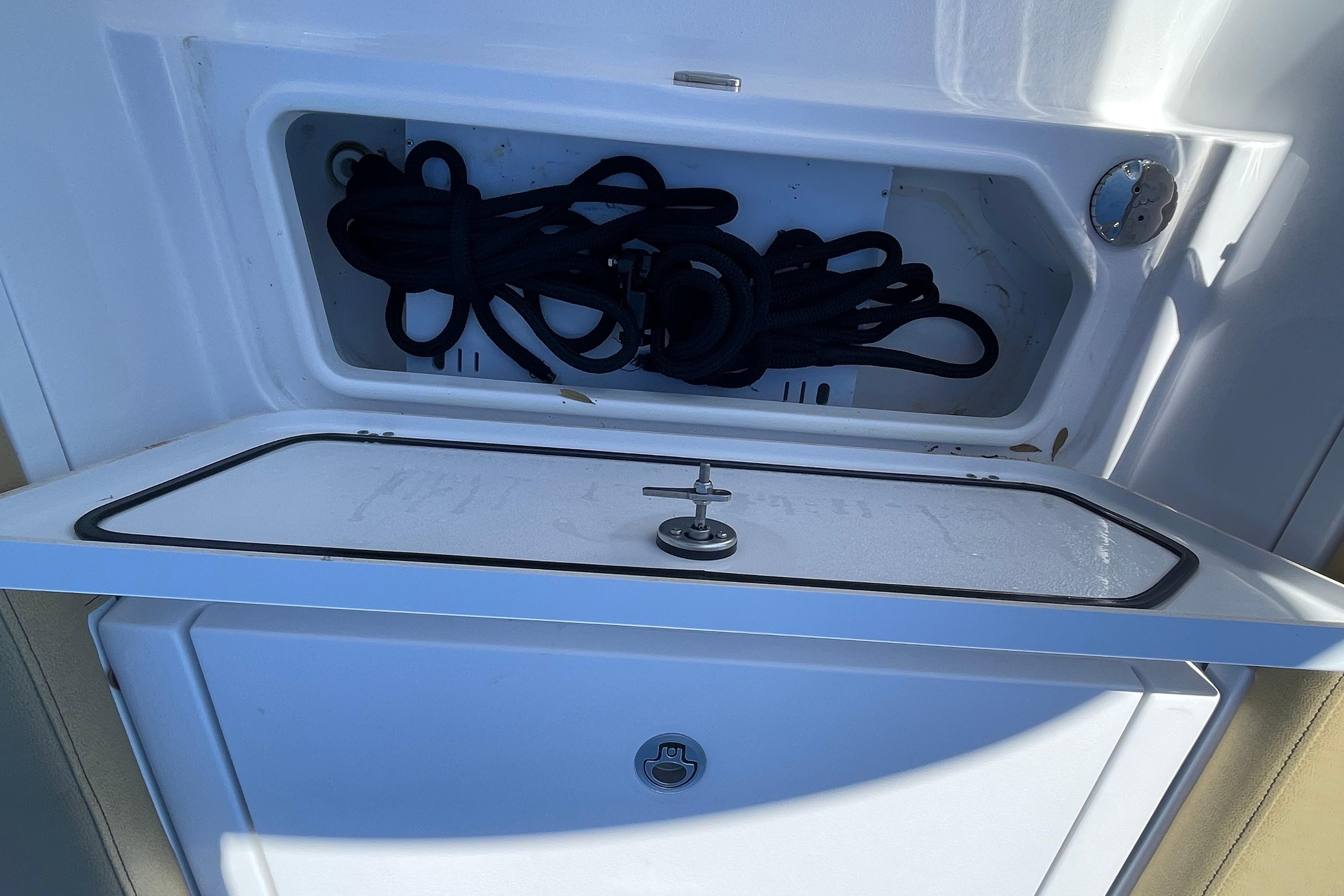 Storage compartment on a 2024 Sportsman Masters 247 Bay Boat, featuring coiled ropes.