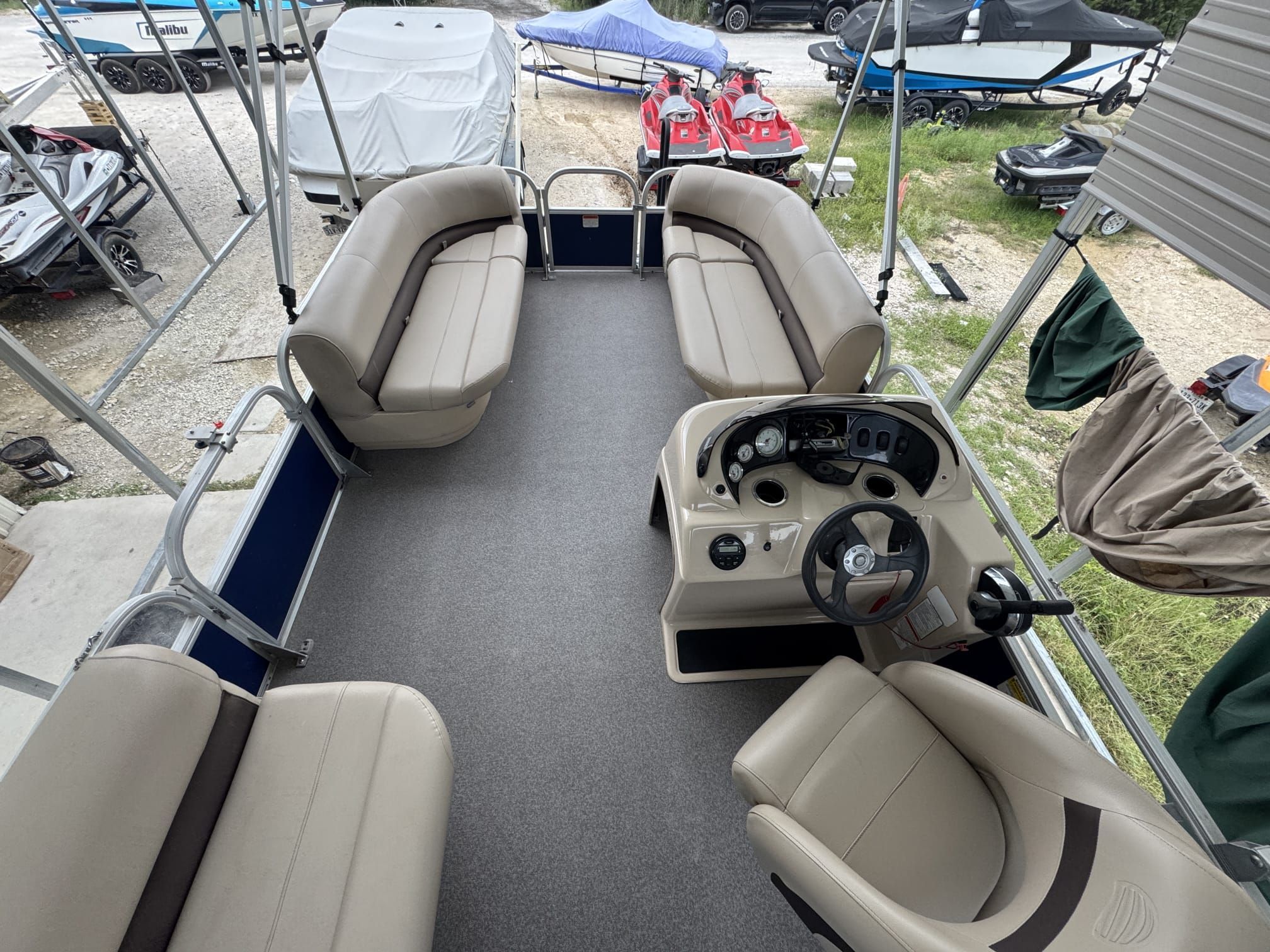 Interior view of a Sun Tracker Party Barge 18 DLX pontoon boat with beige seating and helm.