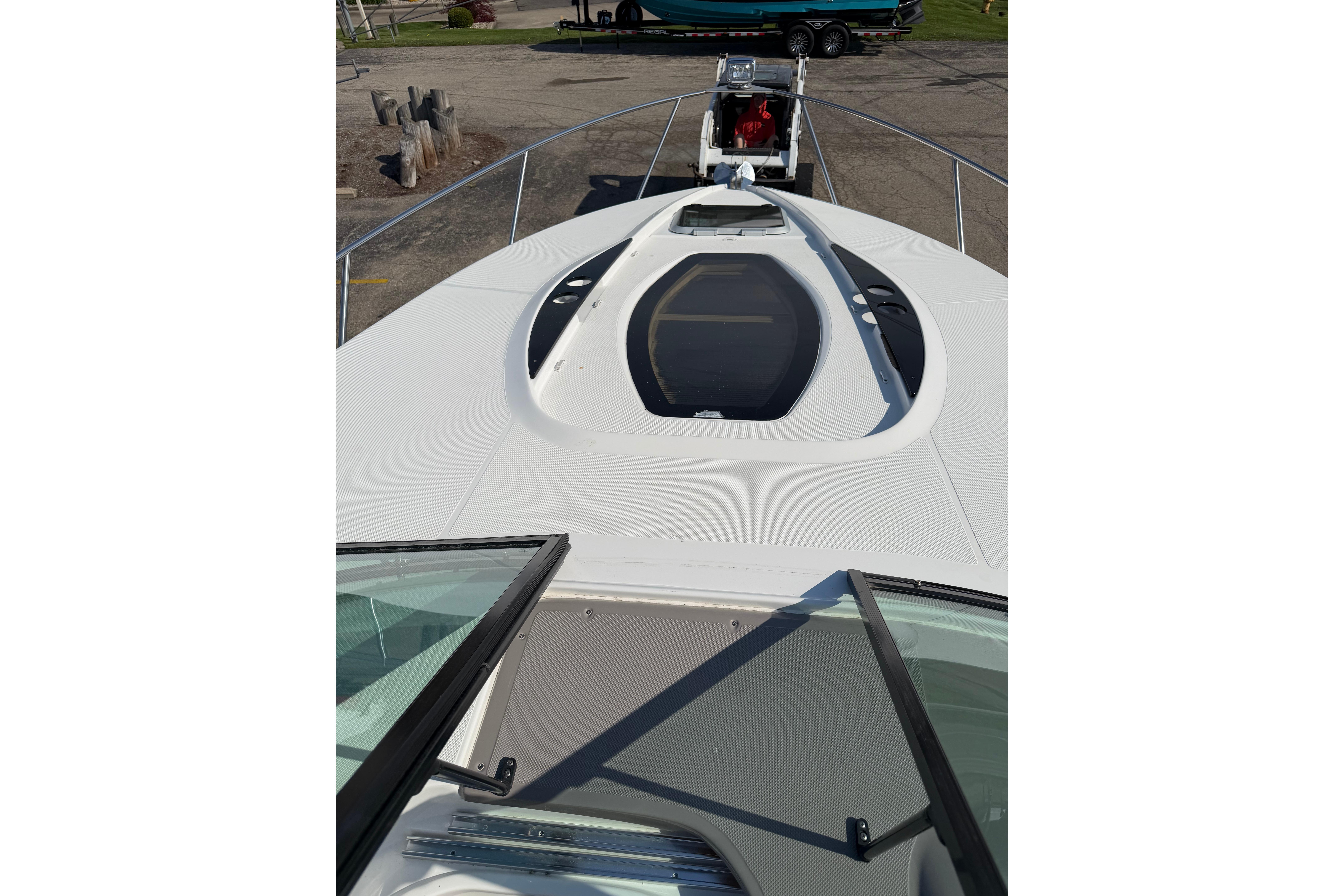 2019 Rinker EX 320 boat deck with open hatch and railing.