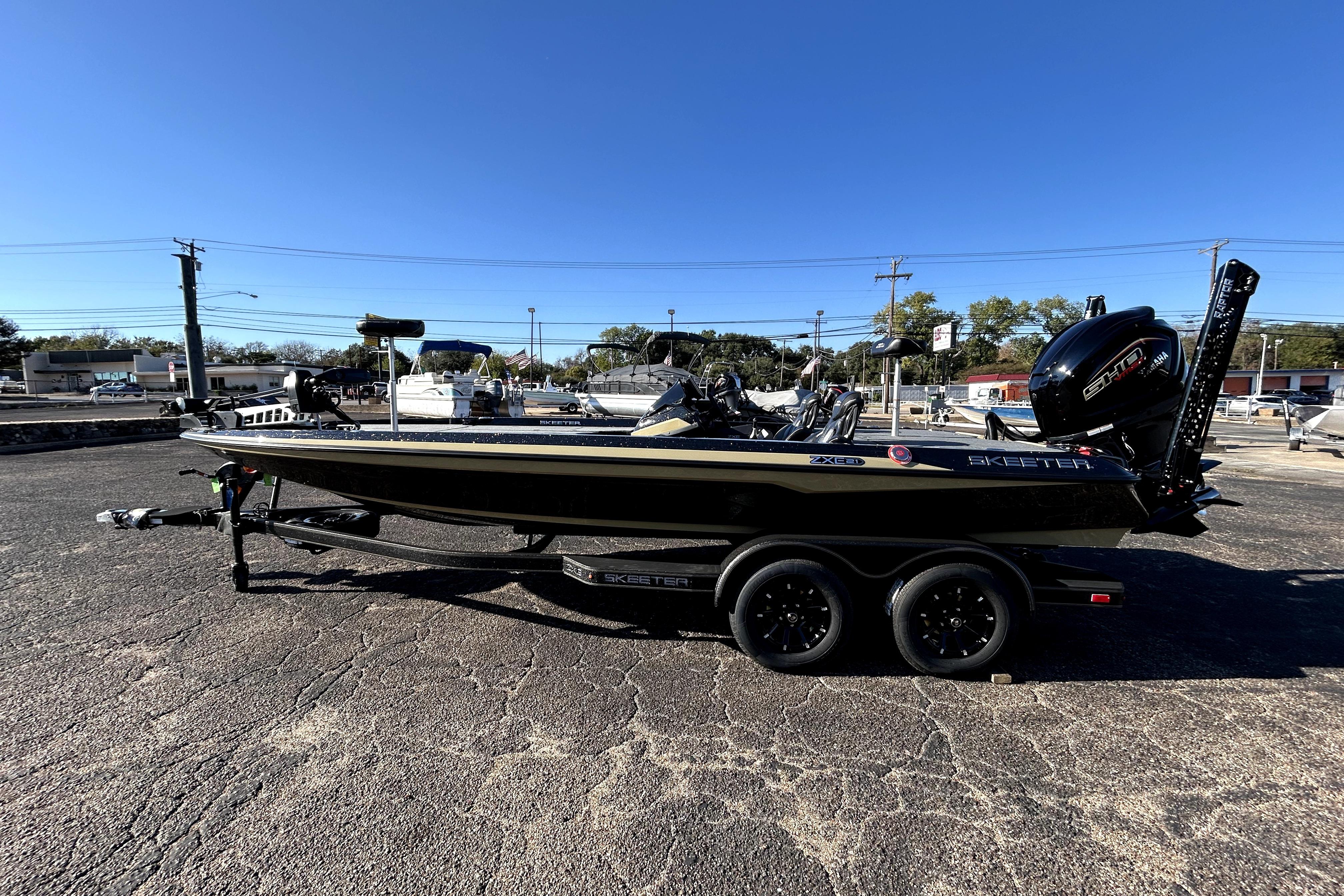 2026 Skeeter ZXE21 boat on trailer in parking lot, clear blue sky.