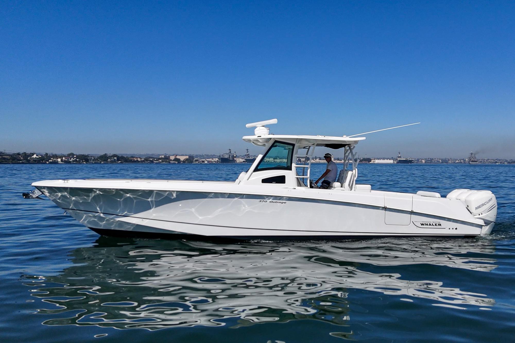 2015 Boston Whaler 370 Outrage boat cruising on calm water under clear blue sky.