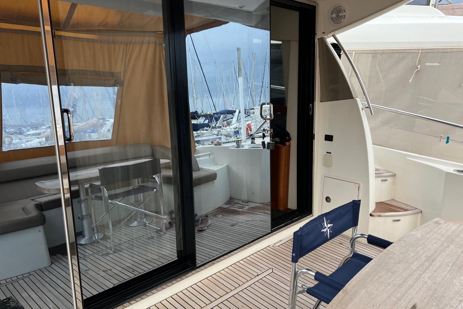 2015 Prestige 500S yacht interior with seating, table, and marina view.