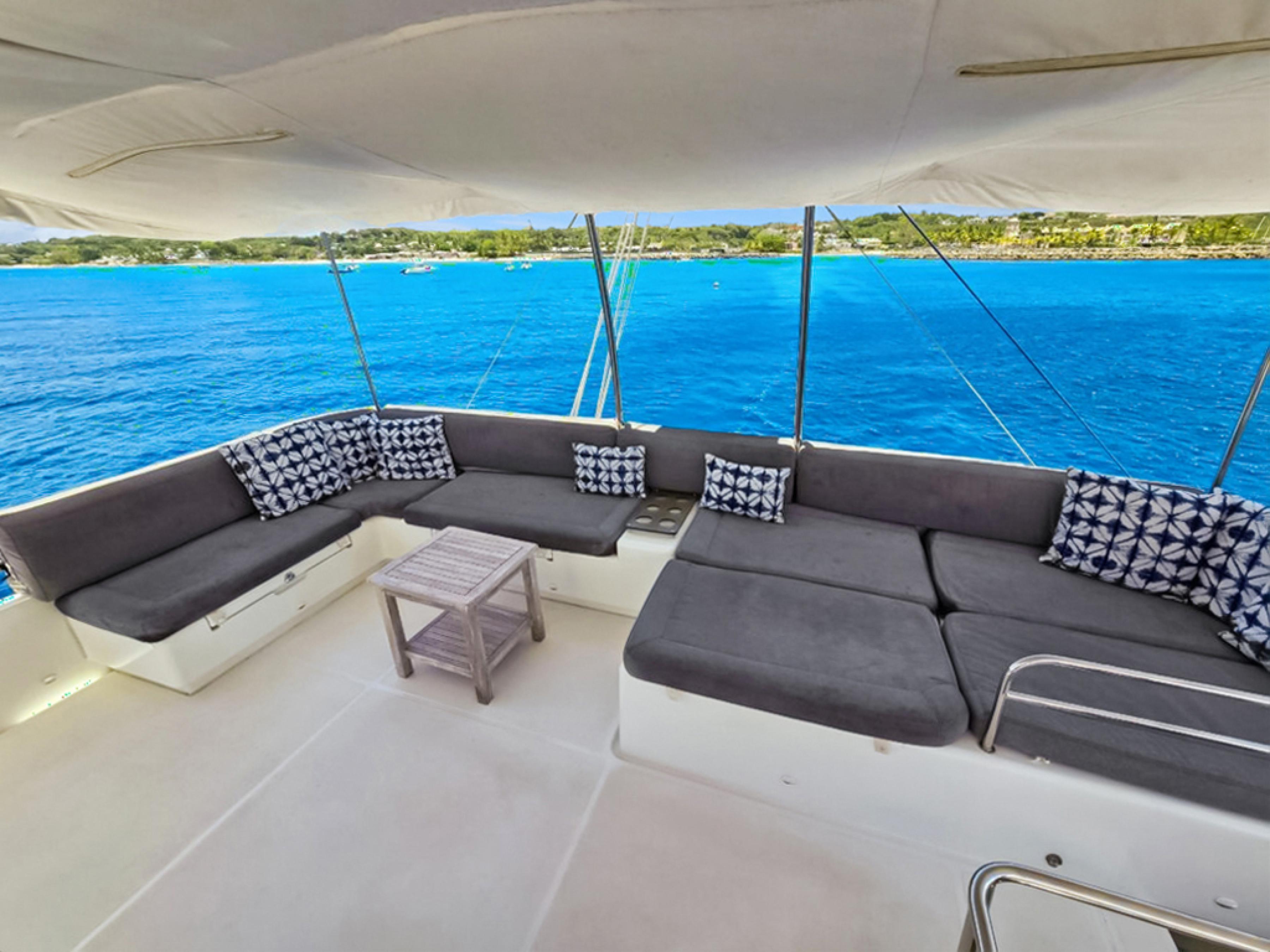 Spacious deck of 2015 Lagoon 560 S2 yacht with comfortable seating and ocean view.