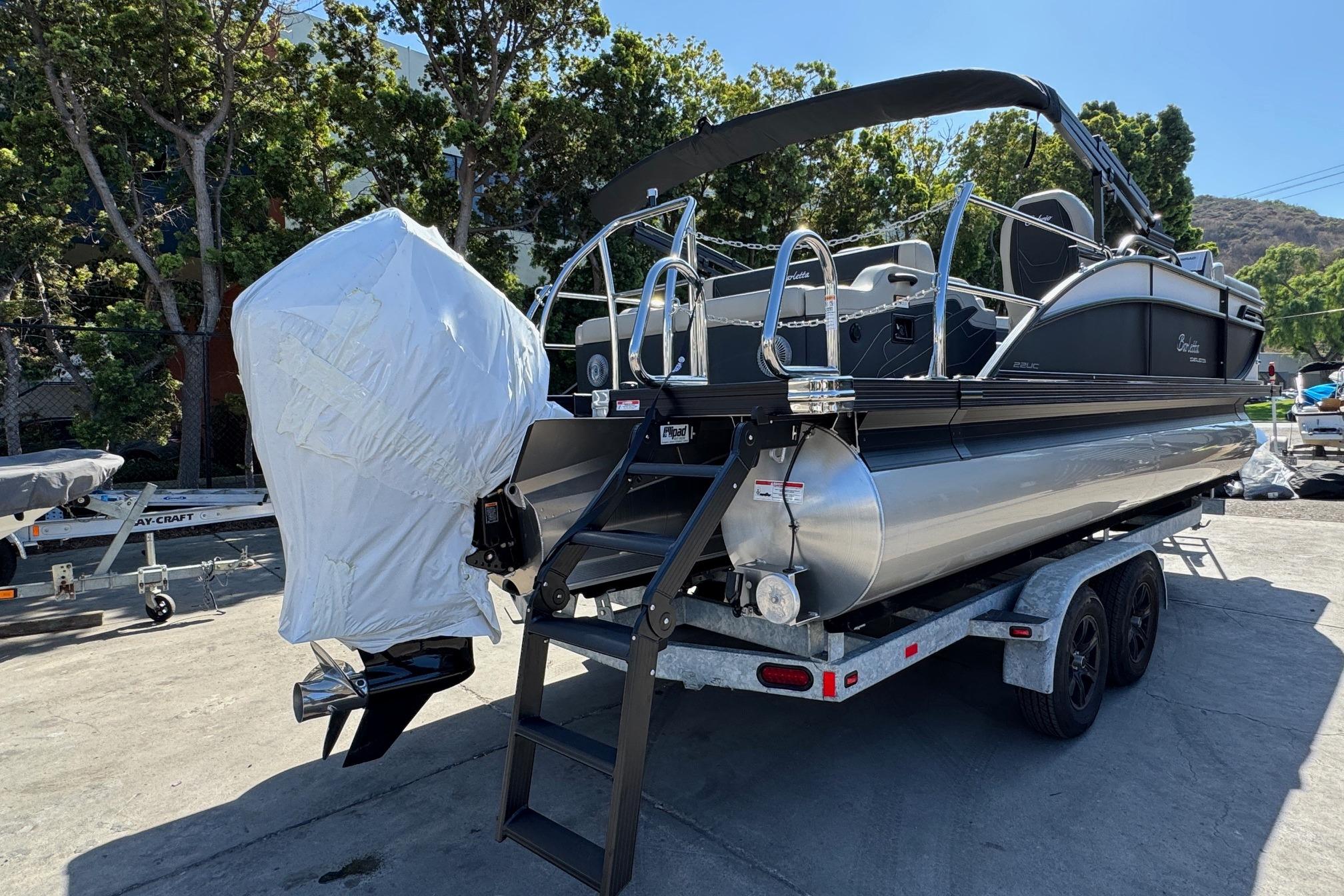 2026 Barletta Cabrio 22UC pontoon boat on trailer, covered engine, outdoor setting.